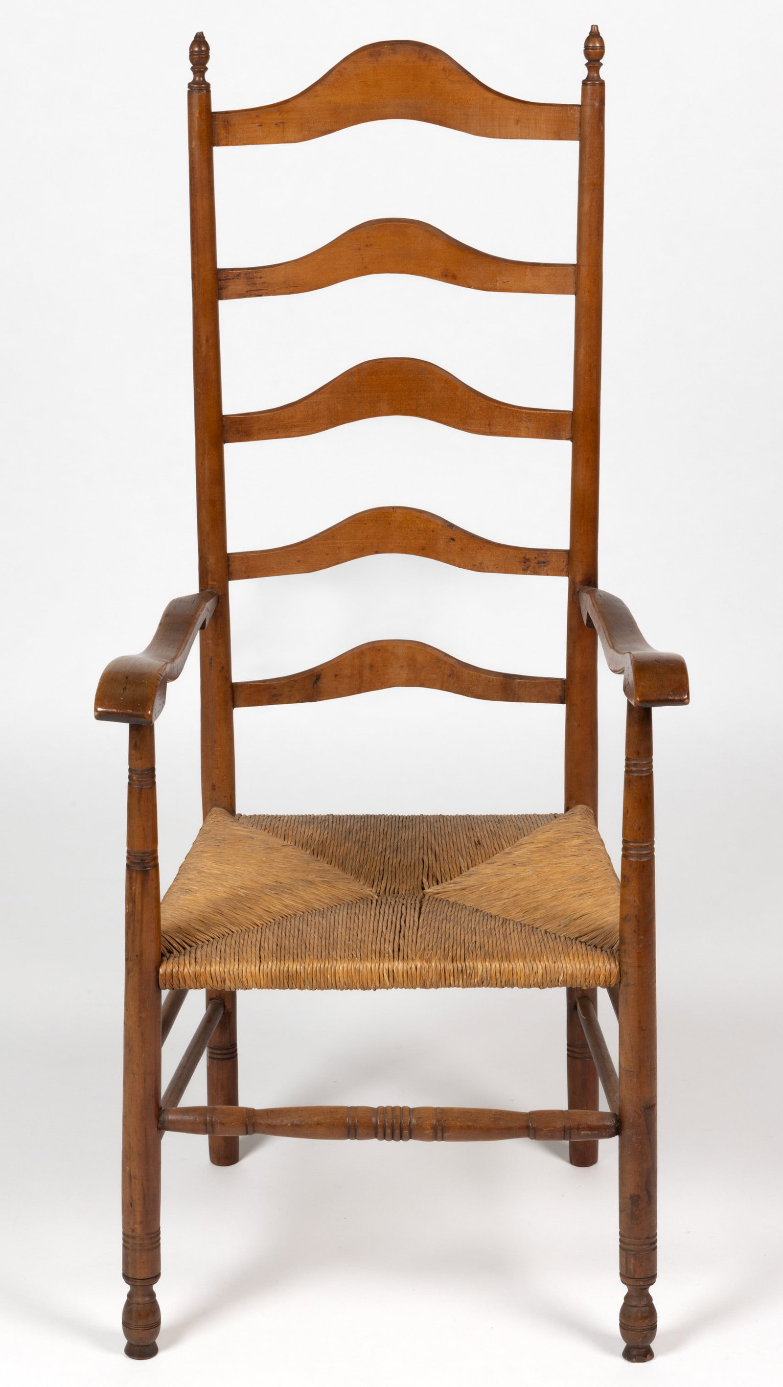 PENNSYLVANIA LADDERBACK ARMCHAIR: PENNSYLVANIA LADDERBACK ARMCHAIR, maple or ash, the back set with five arch-top slates supported on turned posts topped with finials, the shaped arms resting on turned supports tra