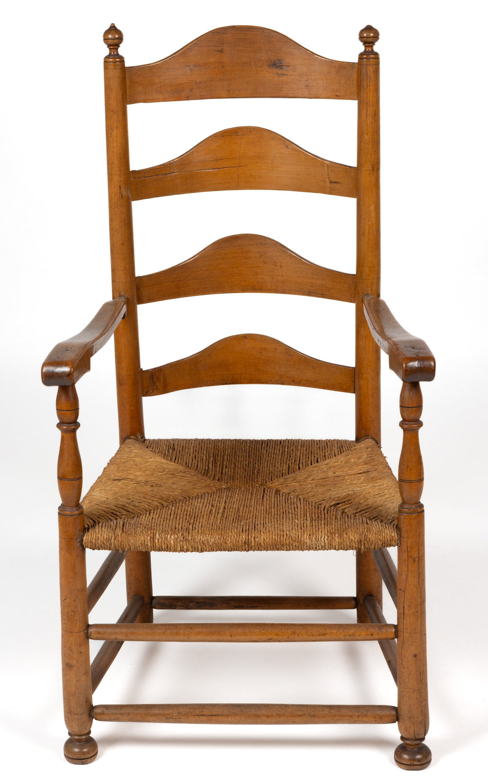 DELAWARE RIVER VALLEY LADDERBACK ARMCHAIR: DELAWARE RIVER VALLEY LADDERBACK ARMCHAIR, the four-slat back flanked by posts with finely turned finials and shaped arm rests over a rush seat raised on turned legs joined with box stretchers. R