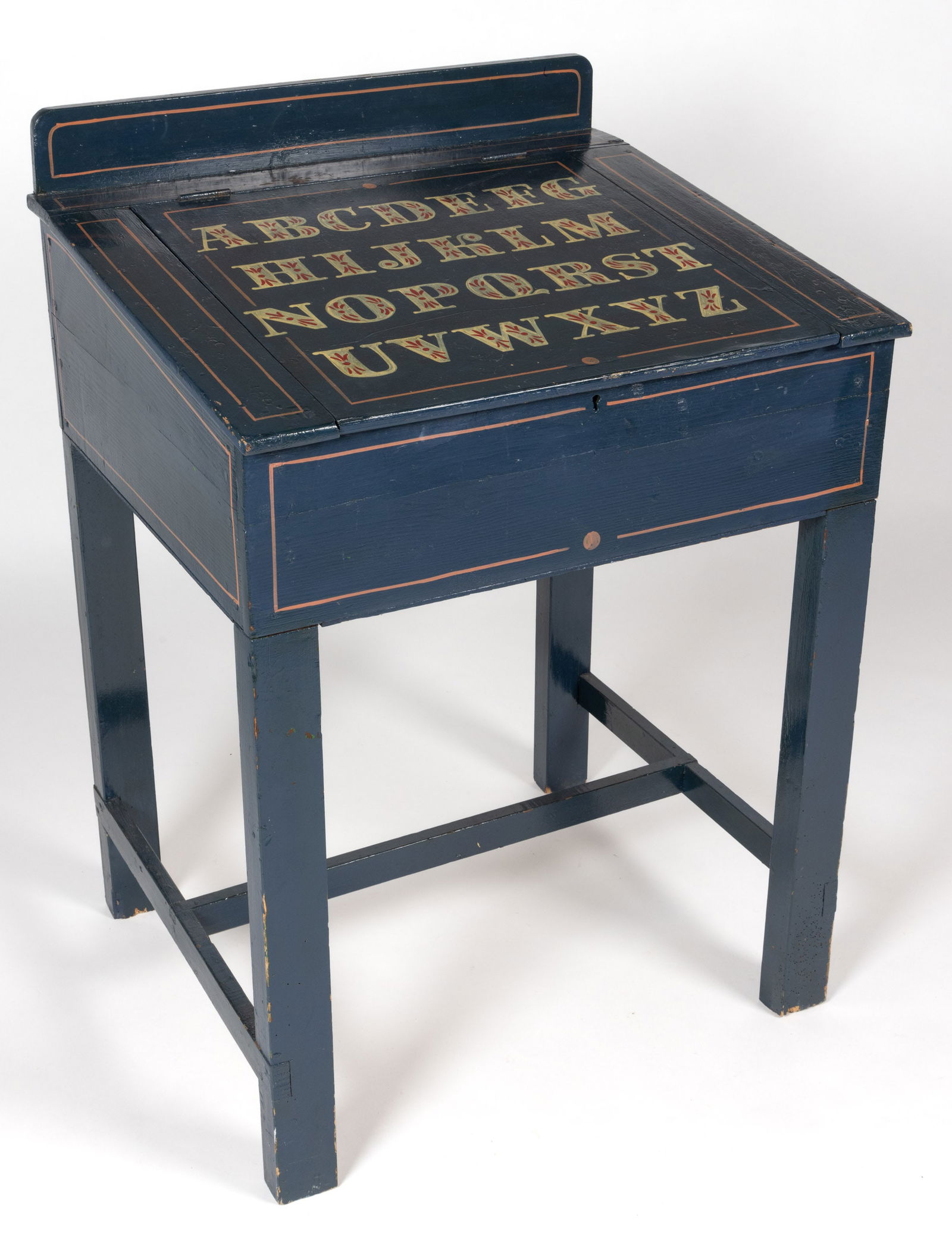 AMERICAN PAINT-DECORATED PINE SCHOOL DESK: AMERICAN PAINT-DECORATED PINE SCHOOL DESK, applied backsplash above hinged slant-front concealing open interior, the whole raised on square legs connected by an H-stretcher. Retains a paint decor