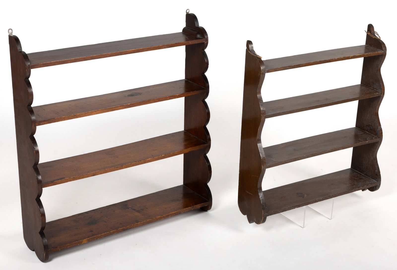 AMERICAN WALNUT HANGING SHELVES, LOT OF TWO: AMERICAN WALNUT HANGING SHELVES, LOT OF TWO, each featuring four tapering shelves set into rabbets in the cut-out sides. Each retains an old natural surface, the smaller with white paint in the wood g