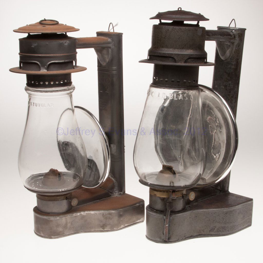 C. T. HAM MANUFACTURING CO. "NO. 12" SHEET IRON COL: C. T. HAM MANUFACTURING CO. "NO. 12" SHEET IRON COLD BLAST TUBULAR WALL LANTERNS, LOT OF TWO, each with wall hook, one with a ring handle to cap, each tube with patent information, colorless globes in