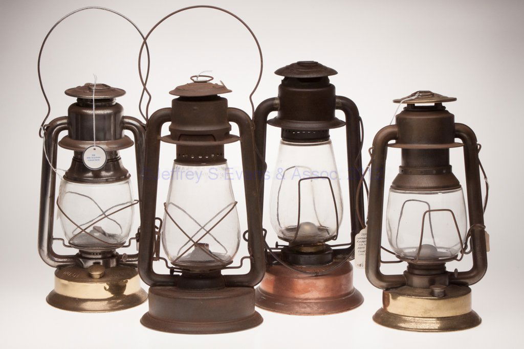 MIXED METALS COLD BLAST TUBULAR LANTERNS, LOT OF FO: MIXED METALS COLD BLAST TUBULAR LANTERNS, LOT OF FOUR, each with bail handle and colorless globe, comprising a sheet iron C. T. Ham Manuf. Co.'s "No. 2", globe embossed "HAM'S COLD BLAST MATCHLESS"; a