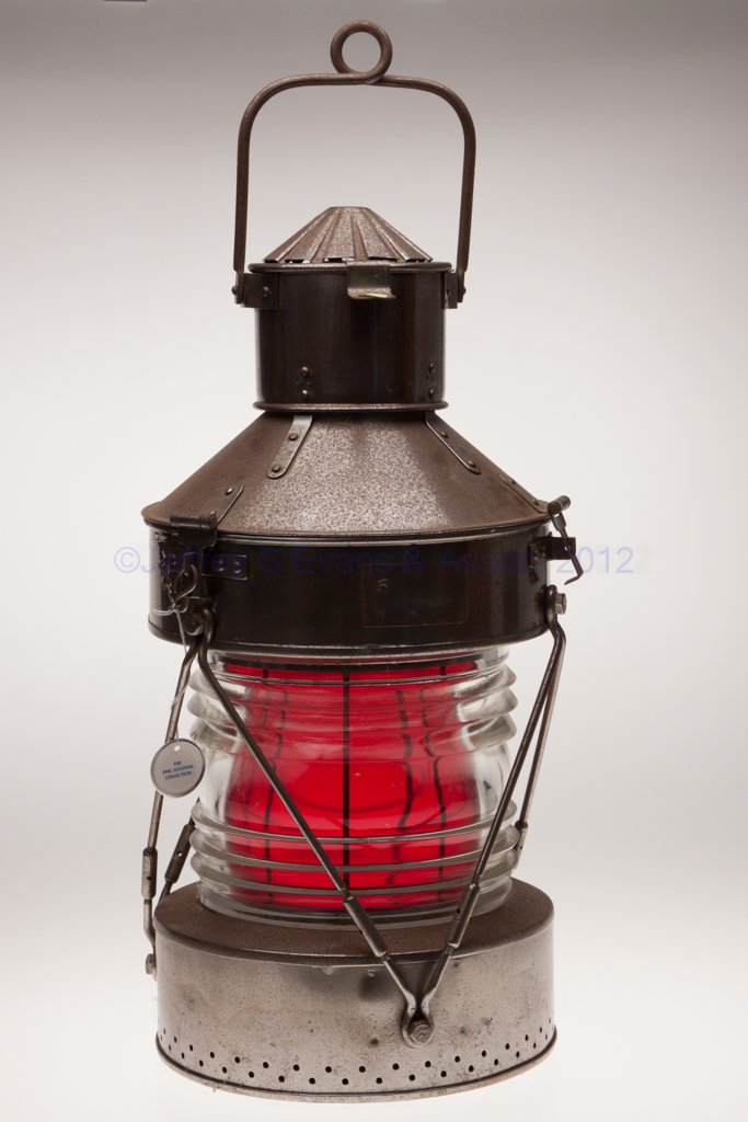 SHEET IRON ANCHOR MARINE LANTERN: SHEET IRON ANCHOR MARINE LANTERN, bail handle and hinged cover, cover with illegible maker's plate marked "PTC" and with various numbers, underside of base with a large tie-down ring, colorless 360 de