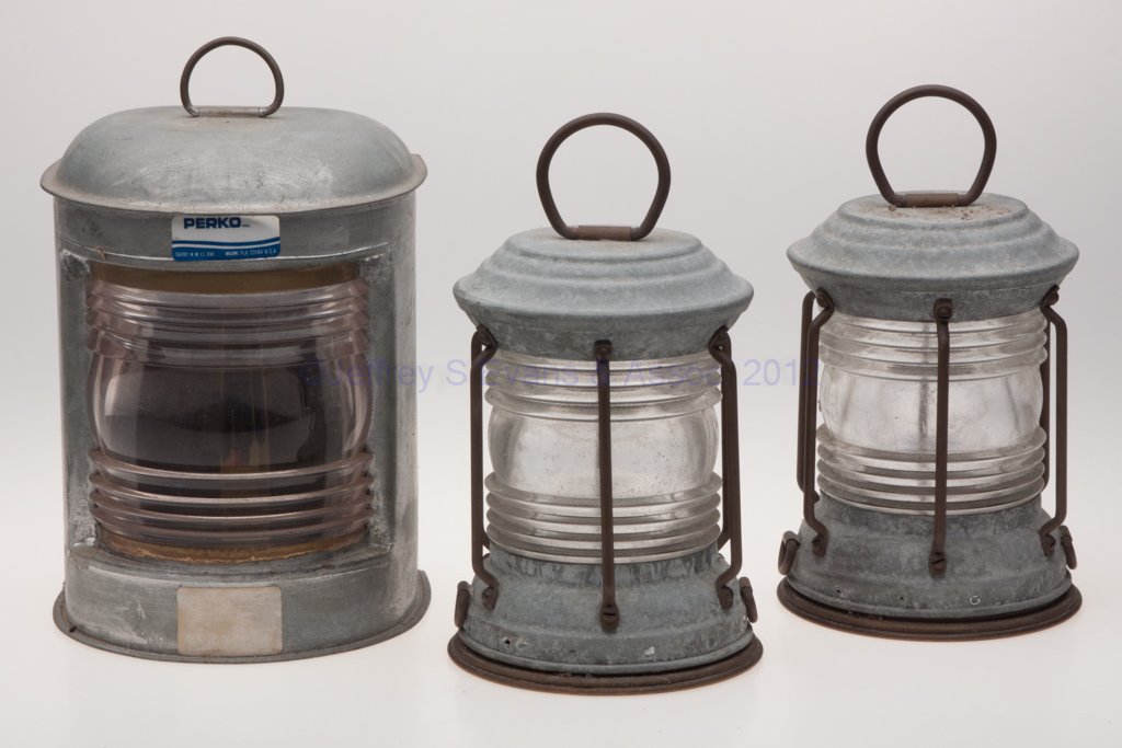 SHEET IRON ELECTRIC MARINE LIGHTING, LOT OF THREE: SHEET IRON ELECTRIC MARINE LIGHTING, LOT OF THREE, each with ring handles, comprising a Perko example, colorless fresnel lens and mounting bracket; and a pair of unmarked examples with colorless 360 d