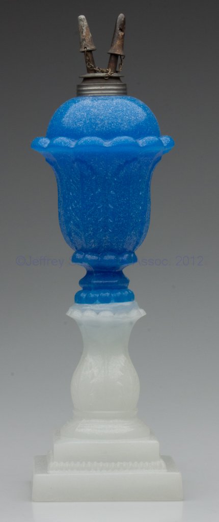 PRESSED ACANTHUS LEAF STAND LAMP: PRESSED ACANTHUS LEAF STAND LAMP, translucent starch blue font, alabaster/clambroth base, overall sanded surface, dome-top font with 12 protruding petals below the shoulder and a short hexagonal exten