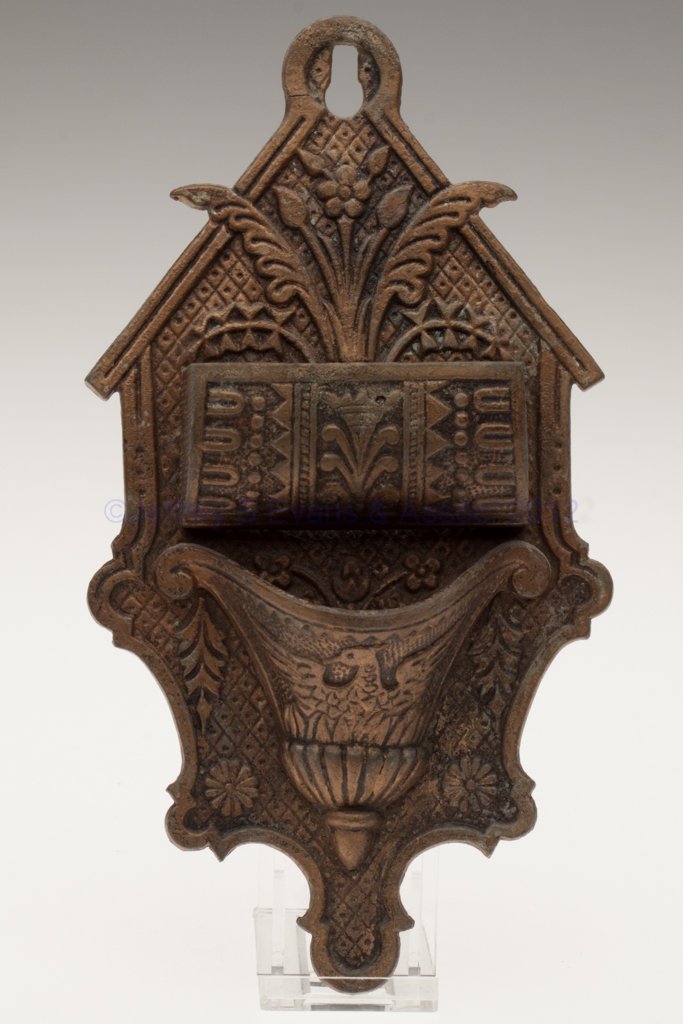 CAST SPELTER WALL-MOUNT MATCH HOLDER: CAST SPELTER WALL-MOUNT MATCH HOLDER, brass finish, double open compartments comprising a cylinder form with striker plate ends over an urn form with eagle embossing, reverse embossed "PAT. APLD. FOR.