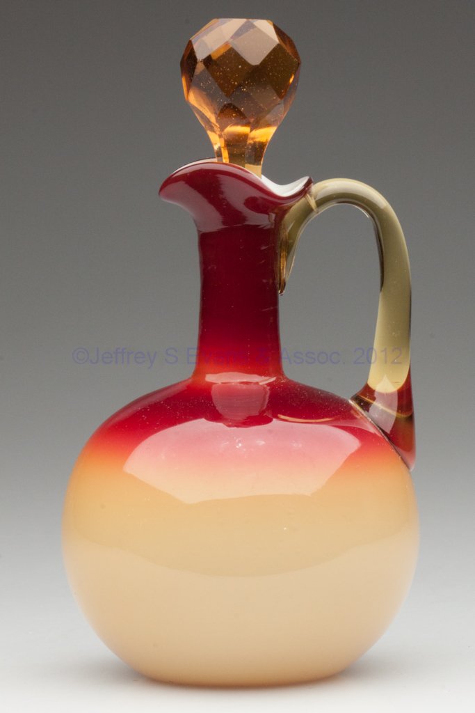 HOBBS CORAL / PEACH BLOW CRUET: HOBBS CORAL / PEACH BLOW CRUET, opal cased, globular form, amber applied handle and cut facetted stopper, polished pontil mark. Hobbs, Brockunier & Co. Circa 1886. 6 3/4" HOA. Provenance: From the col