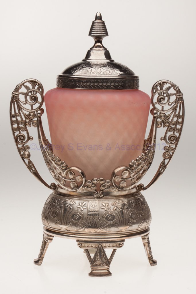 SATIN DIAMOND-OPTIC PICKLE CASTER: SATIN DIAMOND-OPTIC PICKLE CASTER, shaded peach, polished pontil mark, Meriden quadruple-plate stand. Possibly Mt. Washington Glass Co. Fourth quarter 19th century. 9 1/2" HOA, 4 3/4" H jar. Provenanc