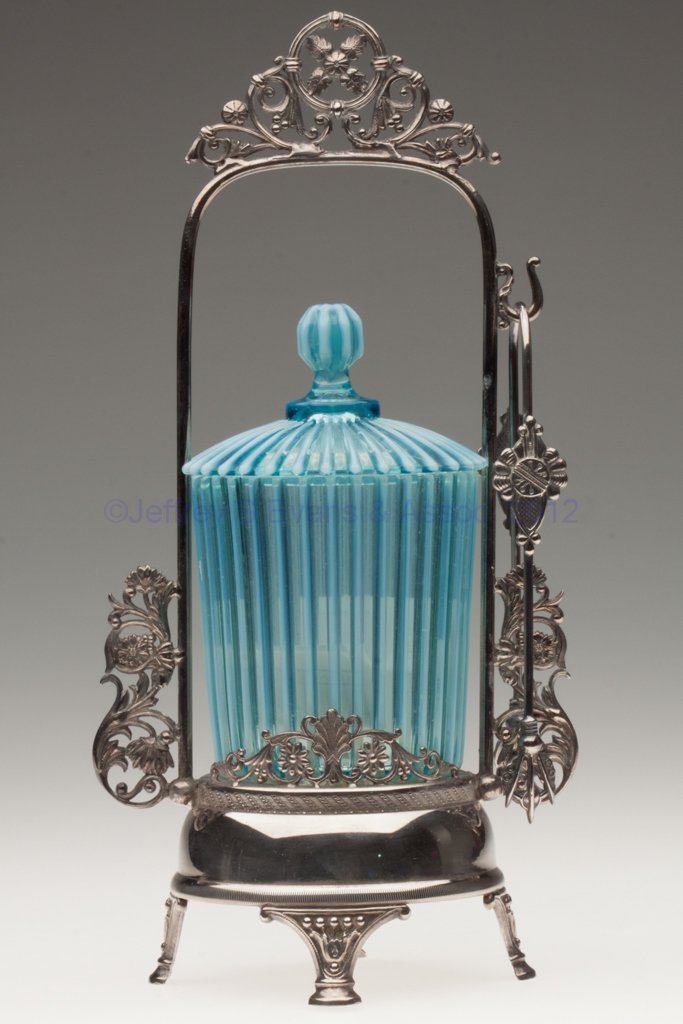 BEATTY RIB PICKLE CASTER: BEATTY RIB PICKLE CASTER, blue opalescent, matching glass cover, American Silver Plate Co. triple-plate stand with tongs. Beatty & Sons, Tiffin, OH. Fourth quarter 19th century. 12" HOA, 5 1/2" HOA ja