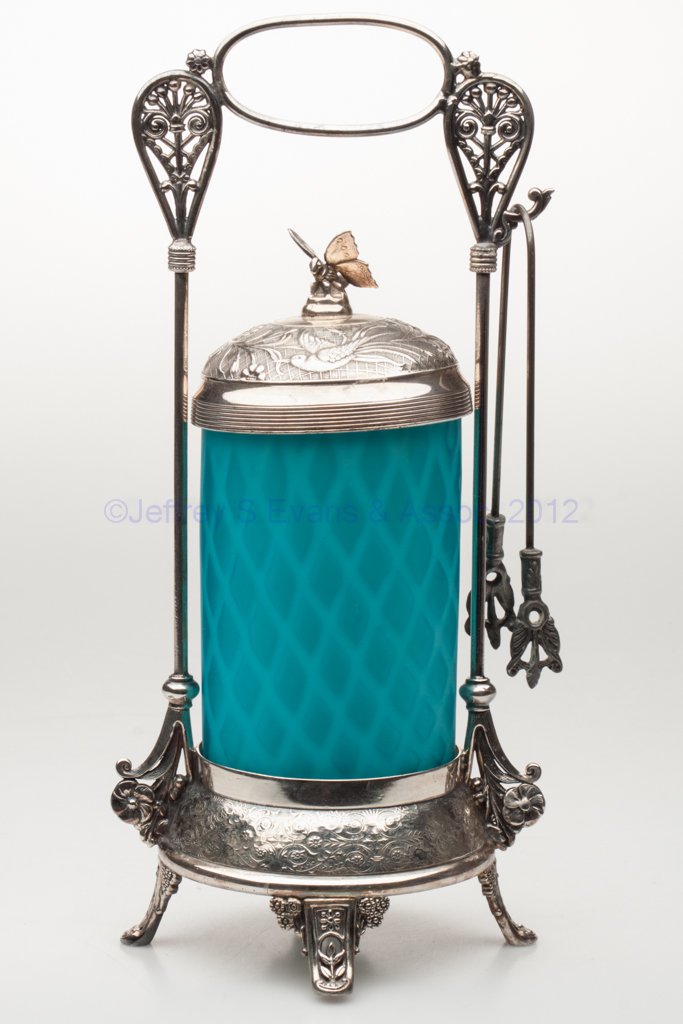 MOTHER-OF-PEARL SATIN PICKLE CASTER: MOTHER-OF-PEARL SATIN PICKLE CASTER, opal cased blue with diamond air traps, ground pontil mark, Rogers Smith & Co., New Haven quadruple-plate stand with tongs. Stand fourth quarter 19th century. Jar 