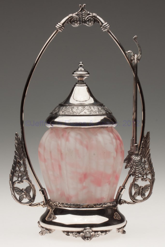 RIBBED PILLAR PICKLE CASTER: RIBBED PILLAR PICKLE CASTER, frosted spatter, Forbes quadruple-plate stand with tongs. Northwood Glass Co. Fourth quarter 19th century. 10 3/4" HOA, 4" H jar. Provenance: From the collection of the la