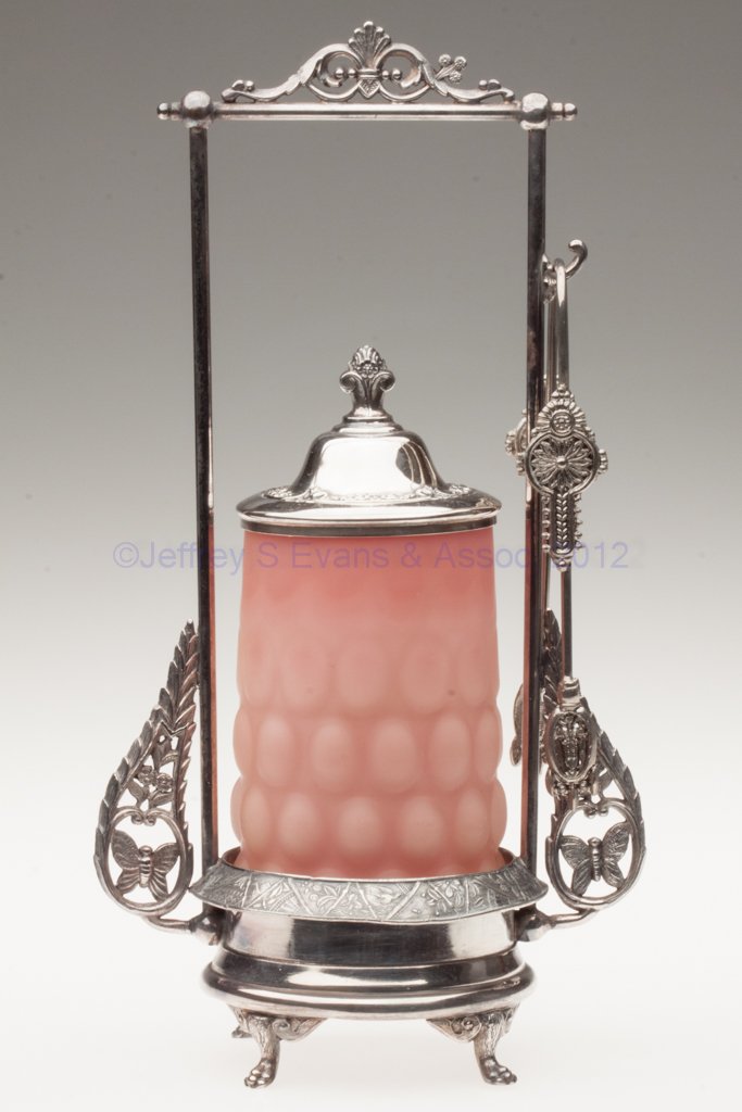 SATIN OVAL HOBNAIL PICKLE CASTER: SATIN OVAL HOBNAIL PICKLE CASTER, cased peach to yellow, rough pontil mark, Hartford #704 triple-plate stand with butterflies and tongs. Stand fourth quarter 19th century. Jar 20th century. 11 3/4" HO