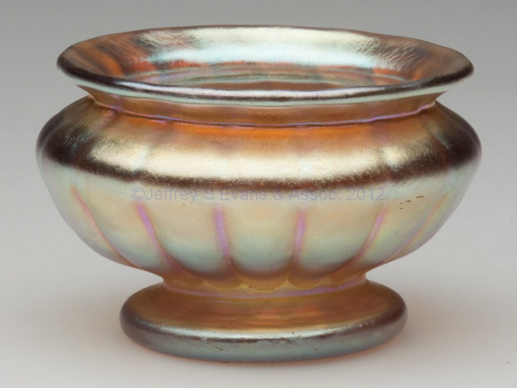 TIFFANY FAVRILE OPEN SALT: TIFFANY FAVRILE OPEN SALT, gold iridescent, melon ribbed footed urn form, signed "L.C.T." outside the polished pontil mark. Louis Comfort Tiffany & Co. First quarter 20th century. 1 1/2" H, 2 1/4" D r