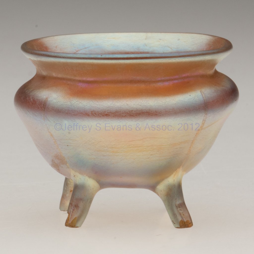 TIFFANY FAVRILE OPEN SALT: TIFFANY FAVRILE OPEN SALT, gold iridescent, witch's pot form raised on four full-height feet, each signed "L.C.T." and "Favrile" outside the polished pontil mark. Louis Comfort Tiffany & Co. First qua