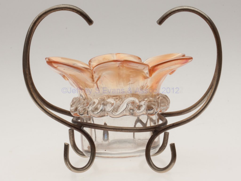 IRIDESCENT RIB-OPTIC OPEN SALT: IRIDESCENT RIB-OPTIC OPEN SALT, apricot with applied colorless rigaree, six-petal flower form, polished pontil mark, fitted in an "EPNS" stand with four feet. Possibly Thomas Webb & Sons, England. Lat