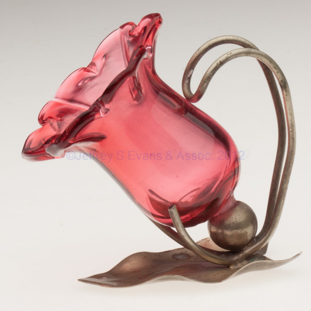 UNPATTERNED OPEN SALT / TOOTHPICK HOLDER: UNPATTERNED OPEN SALT / TOOTHPICK HOLDER, cranberry, flower form fitted in a leaf-form "NS" stand. Late 19th/early 20th century. 3 1/4" H, 2 1/2" D rim. Literature: Jzyk/Robertson - Open Salt Compendi