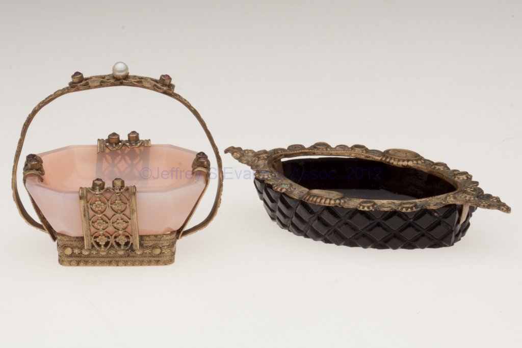 INTAGLIO AND RELATED OPEN SALTS, LOT OF TWO: INTAGLIO AND RELATED OPEN SALTS, LOT OF TWO, comprising an opaque black with an intaglio stag underneath and a brass rim, and an undecorated pink opaline in a brass stand with jewels. Probably Czechos
