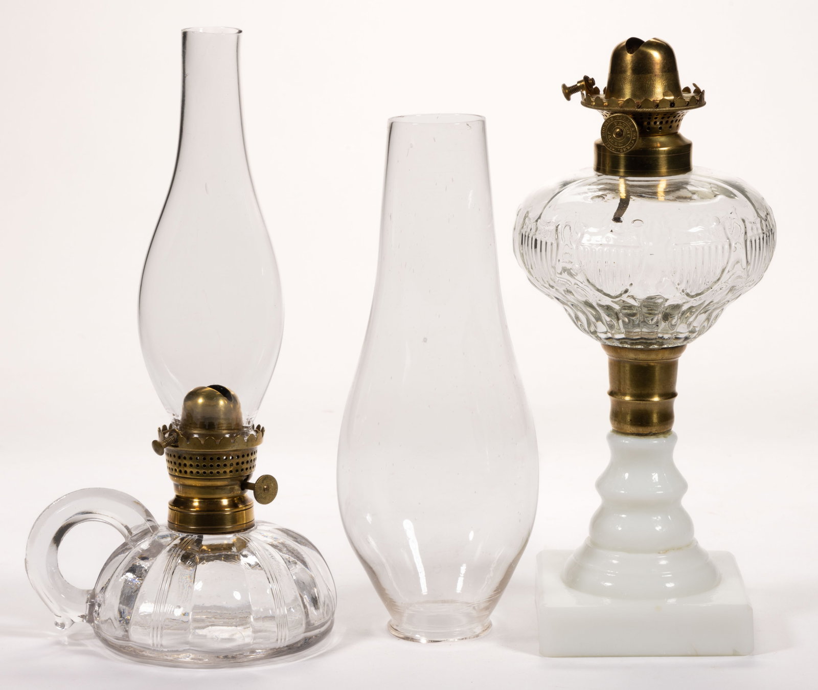 ASSORTED ADLAMS' AND SIMILAR KEROSENE LIP BURNER AND CHIMNEY SETUPS, LOT OF TWO: ASSORTED ADLAMS' AND SIMILAR KEROSENE LIP BURNER AND CHIMNEY SETUPS, LOT OF TWO, brass, comprising a No. 0 example, thumbwheel marked "ADLAMS. PATENT MAY 19. 1862" and with win