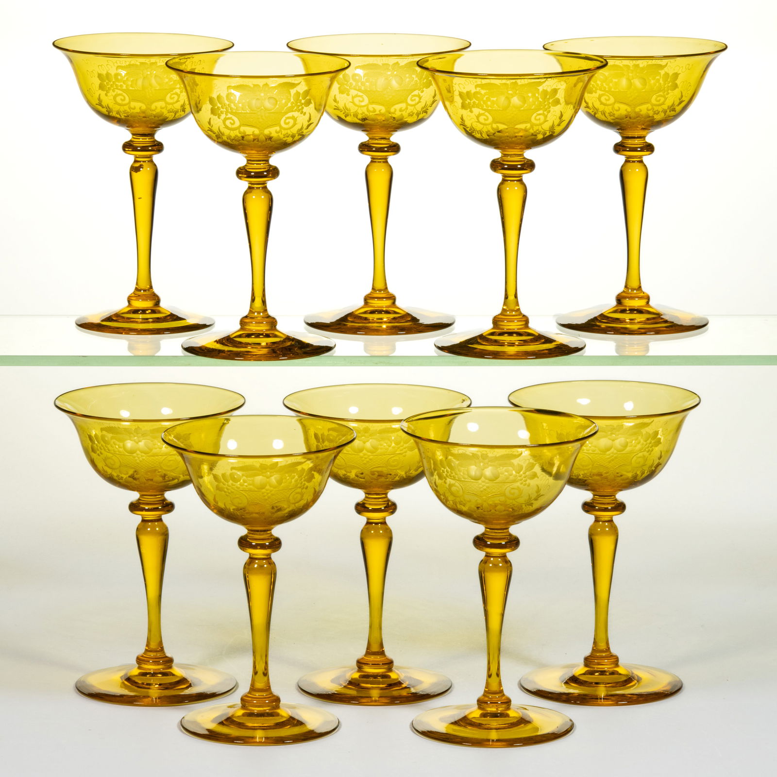 STEUBEN NO. 6401 ENGRAVED ART GLASS CHAMPAGNES, LOT OF TEN: STEUBEN NO. 6401 ENGRAVED ART GLASS CHAMPAGNES, LOT OF TEN, Bristol Yellow, matching decoration depicting a basket of fruits, polished pontil marks. Each with acid-stamped signature. Steuben Glass Wor