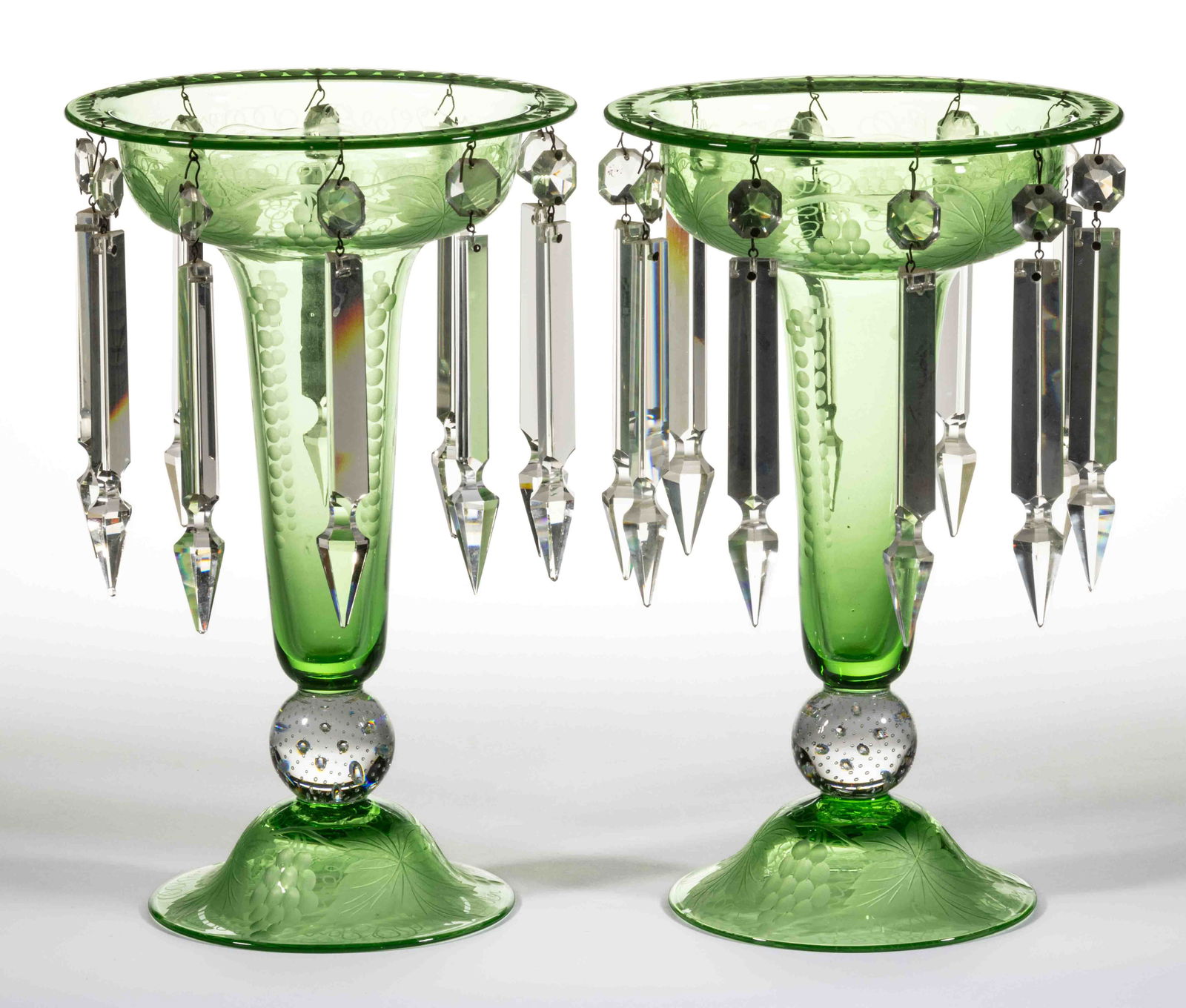 PAIRPOINT GRAPES ENGRAVED ART GLASS PAIR OF MANTLE LUSTERS: PAIRPOINT GRAPES ENGRAVED ART GLASS PAIR OF MANTLE LUSTERS, Green, each B373 form engraved with the Grapes pattern and having a colorless spherical controlled bubble standard. The Pairpoint Corporatio
