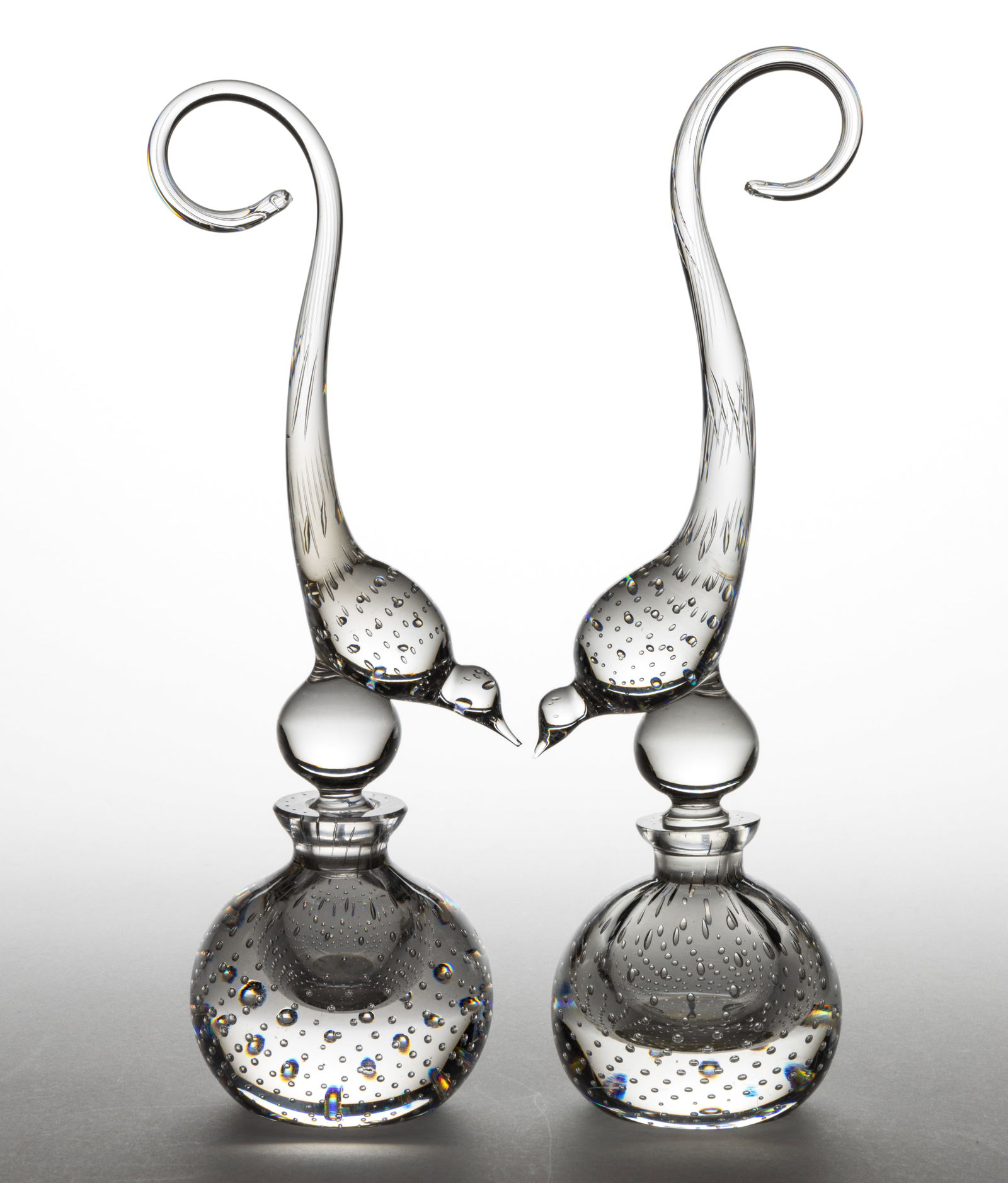 GUNDERSEN / PAIRPOINT FIGURAL BIRD CONTROLLED BUBBLE PERFUME BOTTLES, LOT OF TWO: GUNDERSEN / PAIRPOINT FIGURAL BIRD CONTROLLED BUBBLE PERFUME BOTTLES, LOT OF TWO, colorless, spherical form bottles with spherical stoppers having large bird finials with long, looping tails