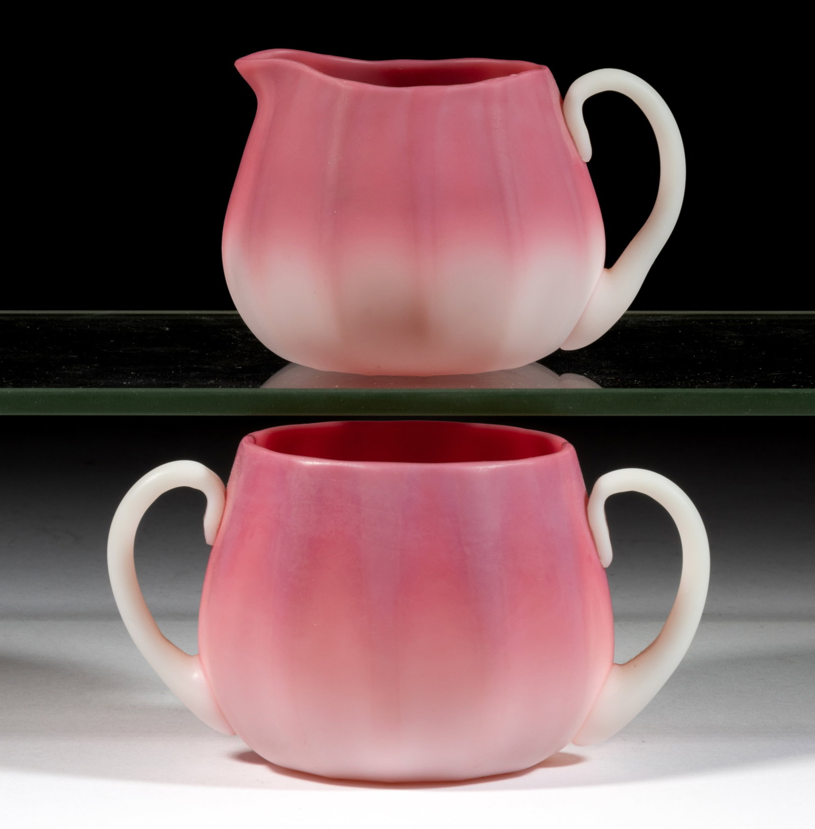 NEW ENGLAND PEACHBLOW RIBBED CREAMER AND SUGAR: NEW ENGLAND PEACHBLOW RIBBED CREAMER AND SUGAR, satin finish, squat globular forms with wide rims and 12 molded vertical ribs around body, applied opal handles, rough pontil marks. New England Gl