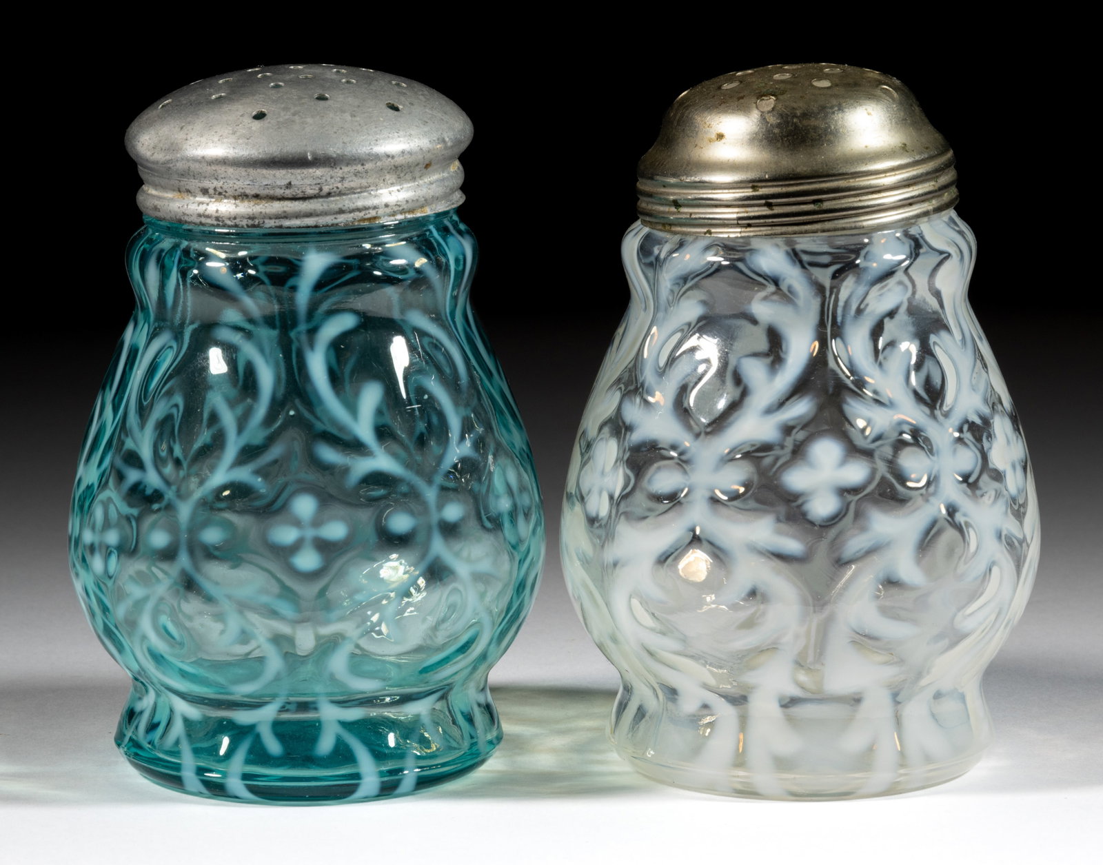 OPALINE BROCADE / SPANISH LACE SUGAR SHAKERS, LOT OF TWO: OPALINE BROCADE / SPANISH LACE SUGAR SHAKERS, LOT OF TWO, colorless opalescent and blue opalescent, each having a period lid. Northwood Glass Co. Pattern introduced in 1899. 4 5/8" and 4 3/4"