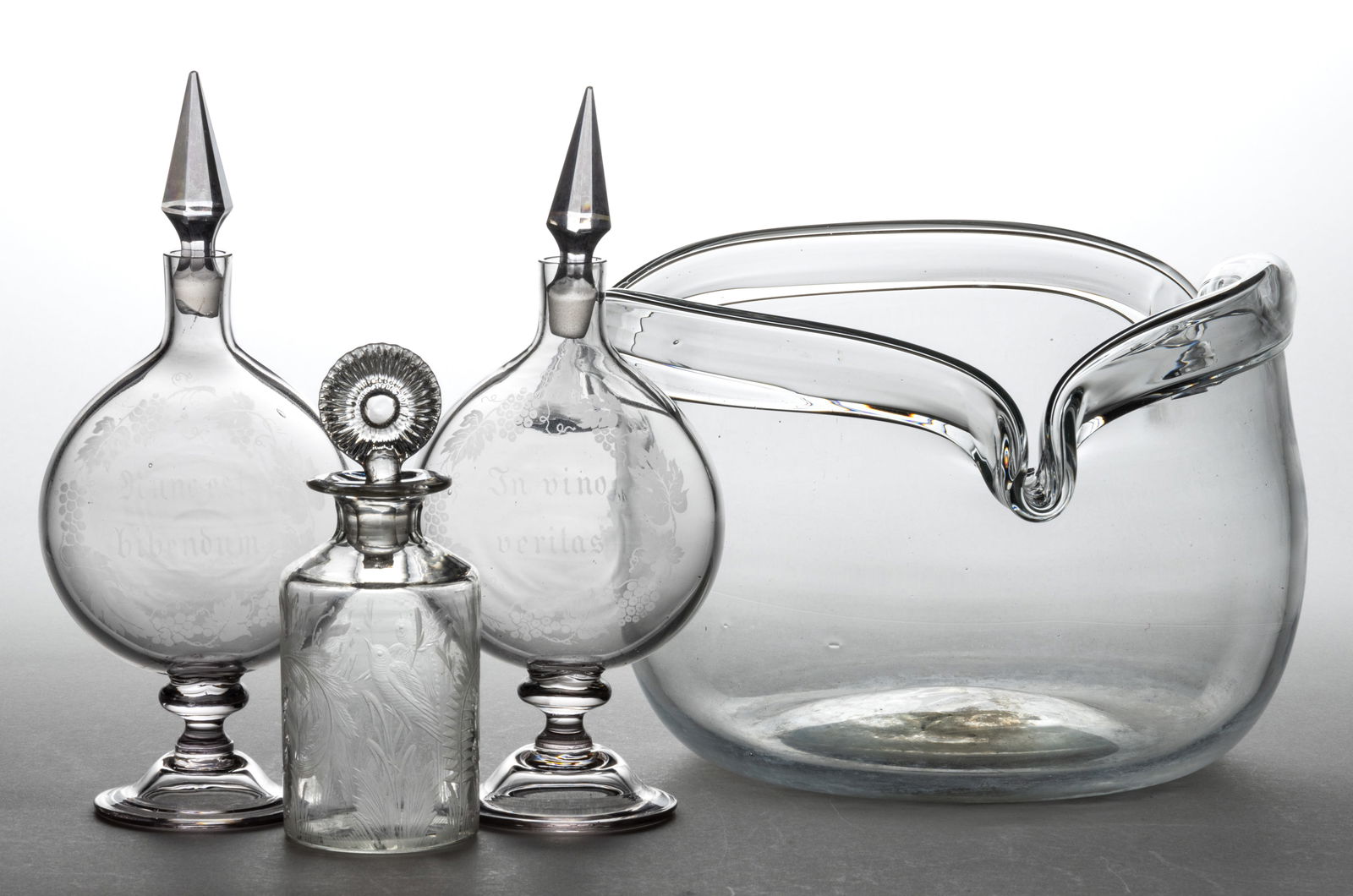 ASSORTED FREE-BLOWN ARTICLES, LOT OF FOUR: ASSORTED FREE-BLOWN ARTICLES, LOT OF FOUR, colorless, comprising a cologne bottle with an elaborate engraving of birds, cattails, and fern, with non-original stopper; a pair of footed flasks having ac