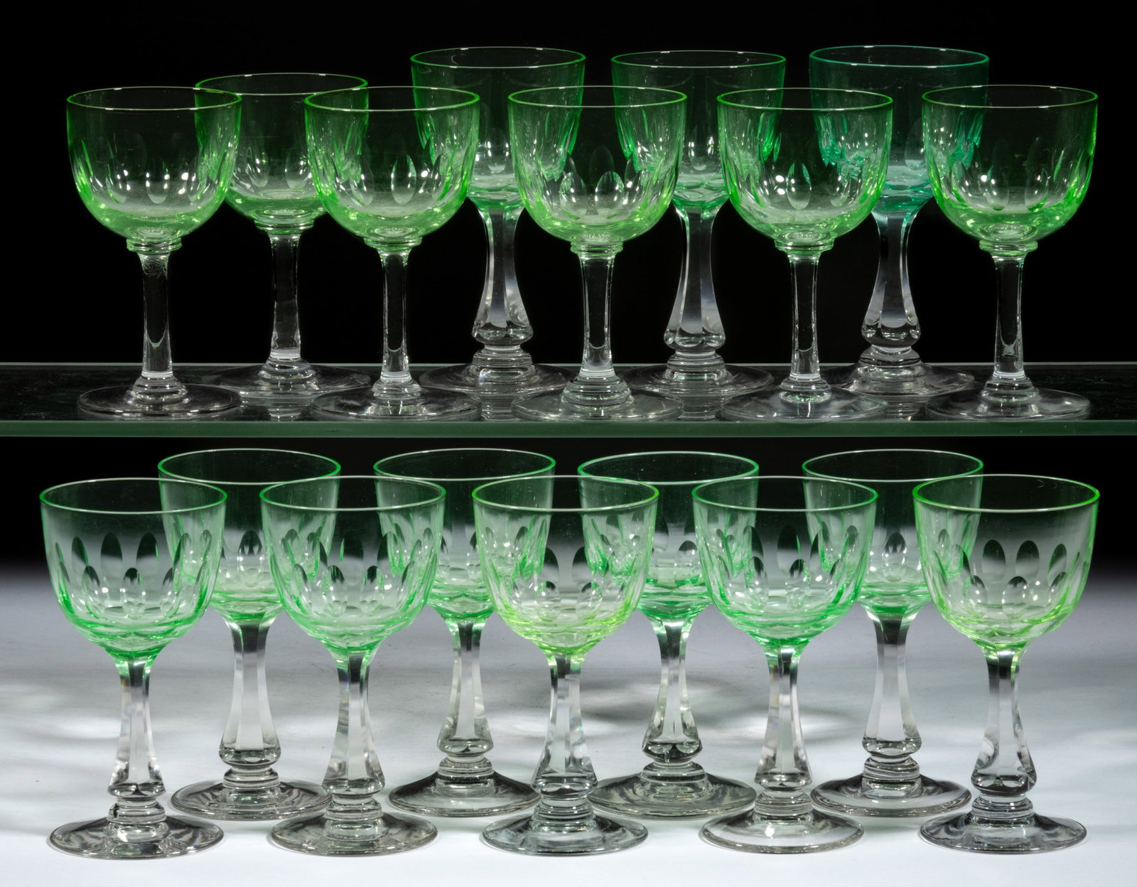 FREE-BLOWN AND CUT WINE GLASSES, LOT OF 18: FREE-BLOWN AND CUT WINE GLASSES, LOT OF 18, each with apple green (reacts under black light) bowl having cut ovals, raised on a colorless stem and foot, two with polished pontil mark. First half 20th 