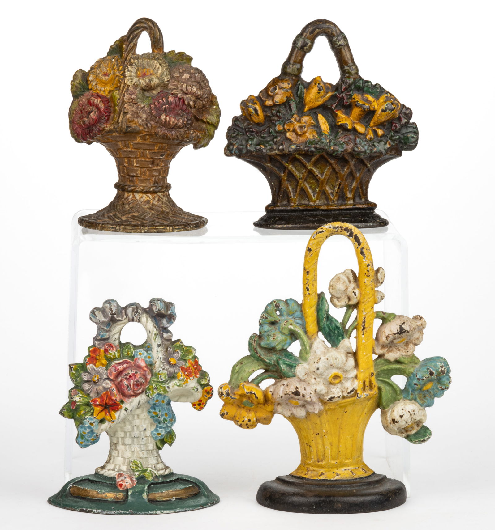 ASSORTED MANUFACTURERS CAST-IRON FIGURAL FLORAL BASKET DOORSTOPS, LOT OF FOUR: ASSORTED MANUFACTURERS CAST-IRON FIGURAL FLORAL BASKET DOORSTOPS, LOT OF FOUR, each of flat-back form, original paint, comprising two National Foundry examples, including a No. 42 with reverse in
