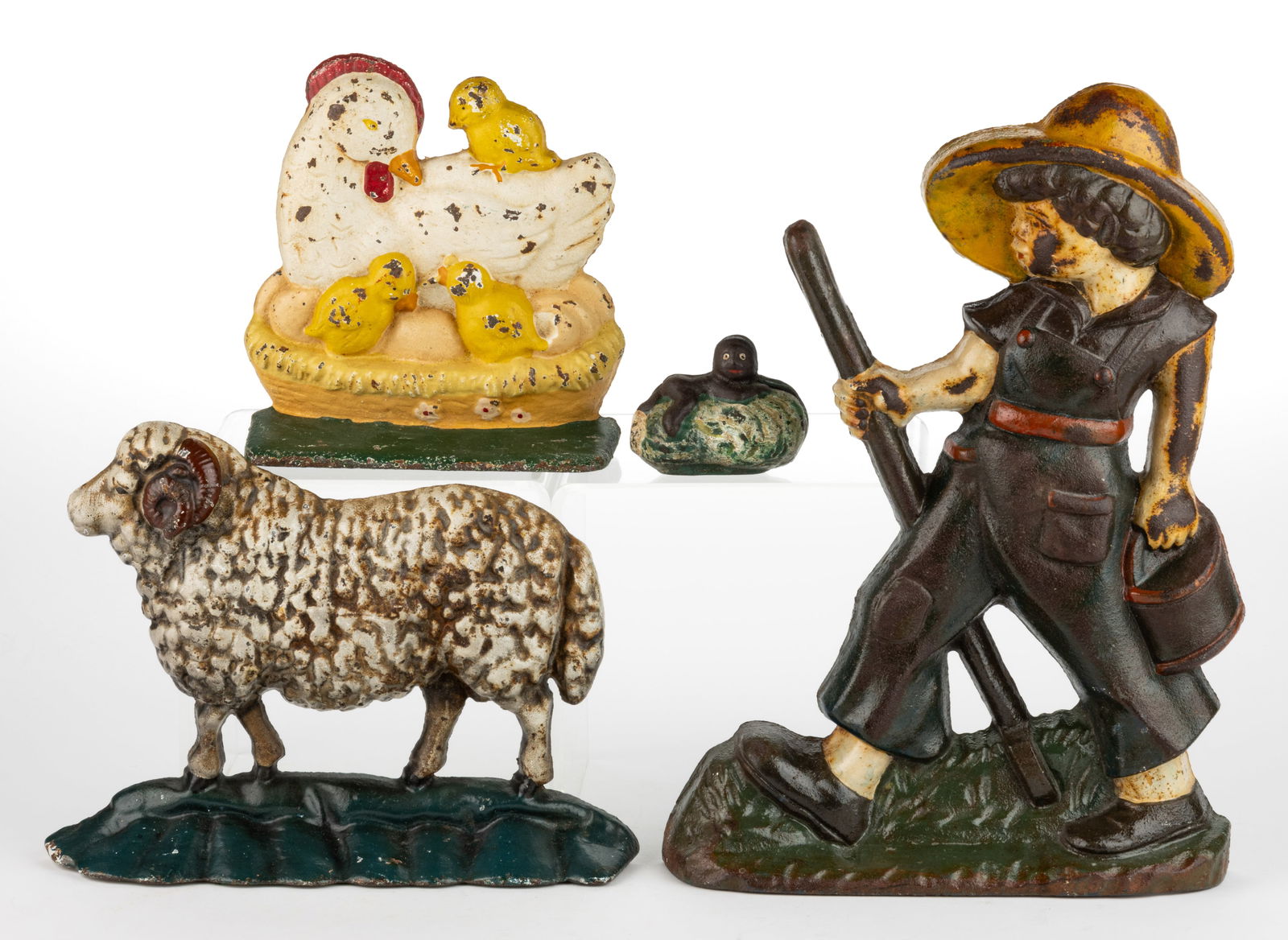 ASSORTED CAST-IRON FIGURAL DOORSTOPS AND BANK, LOT OF FOUR: ASSORTED CAST-IRON FIGURAL DOORSTOPS AND BANK, LOT OF FOUR, original paint, comprising three half-back form examples, including Huckleberry Finn, Julia sheep, and a hen with chicks; and a full-figured