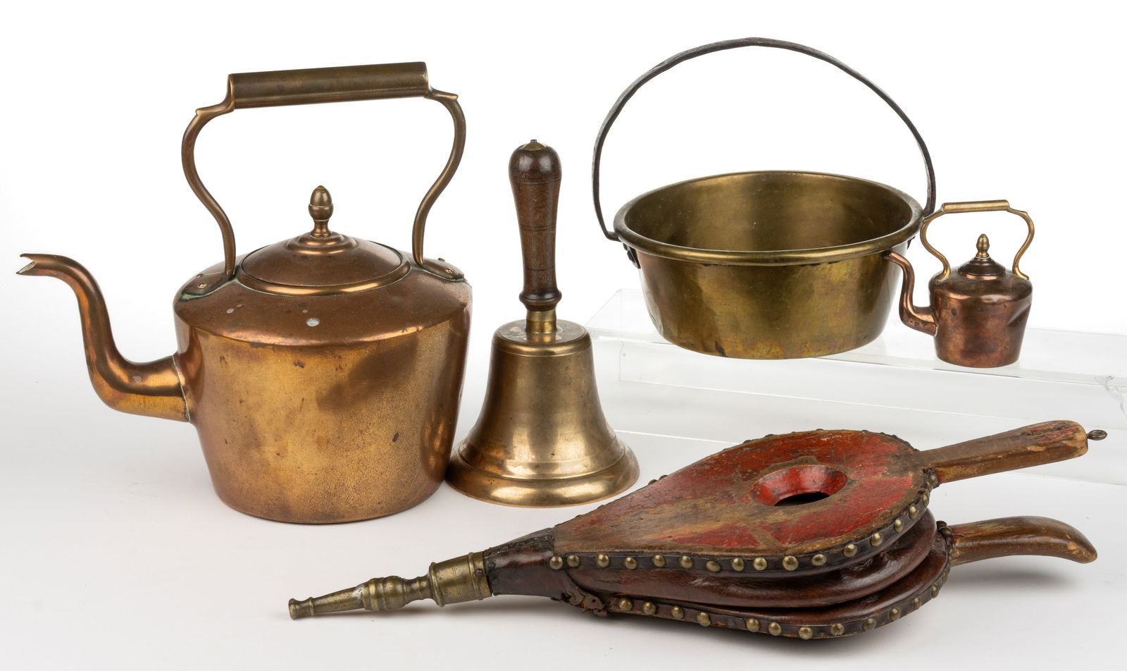 ASSORTED COPPER AND BRASS ARTICLES, LOT OF FIVE: ASSORTED COPPER AND BRASS ARTICLES, LOT OF FIVE, comprising a teapot, a miniature teapot, a school-type bell, a brass pan with iron handle, and bellows with old red-painted surface. 19th/early 20th ce