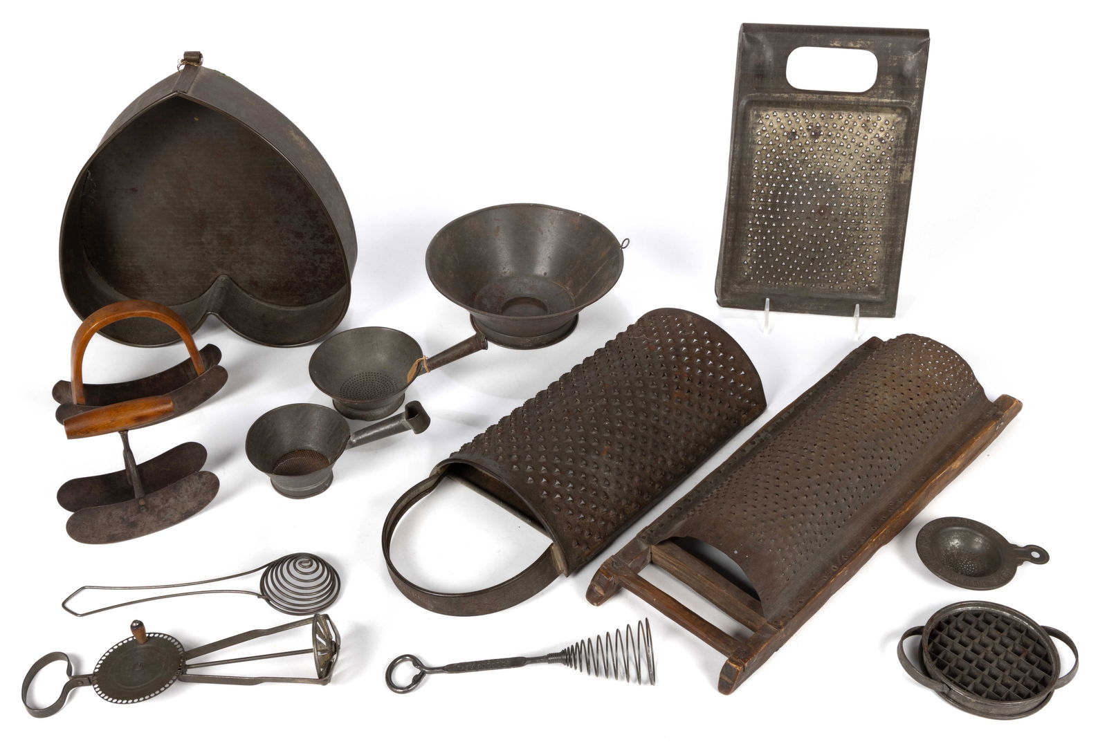 ASSORTED AMERICAN SHEET-IRON DOMESTIC ACCESSORIES, LOT OF 14: ASSORTED AMERICAN SHEET-IRON DOMESTIC ACCESSORIES, LOT OF 14, including graters, several strainers and sieves, whisks, and choppers with wooden handles. Second half 19th/first half 20th century. Large