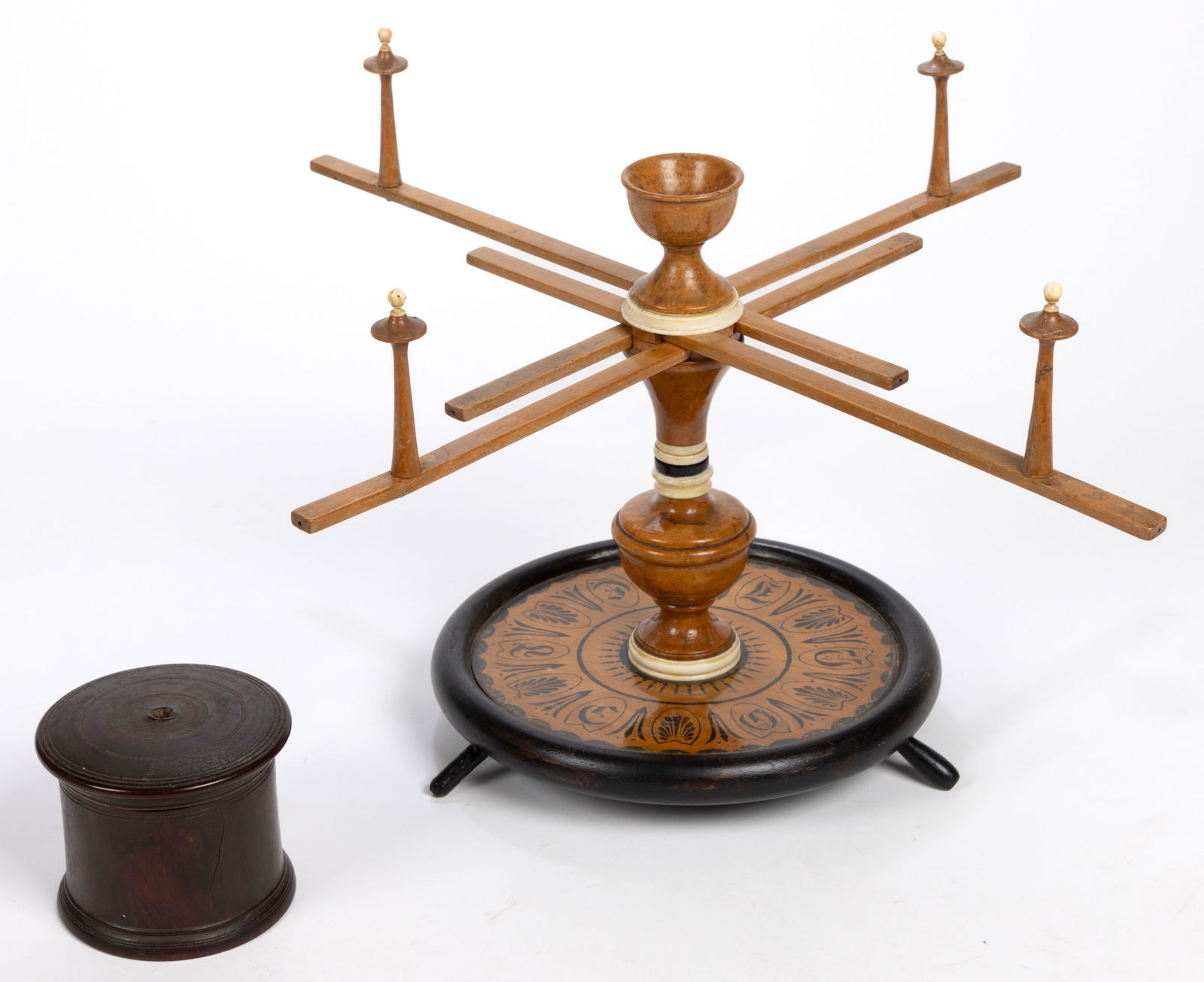 ANTIQUE MAPLE AND BONE SEWING SWIFT / WINDER: ANTIQUE MAPLE AND BONE SEWING SWIFT / WINDER, with turned pedestal and platform base bearing stenciled decoration. Together with a treen string box. Two pieces total. 19th century. Swift 11 1/2"