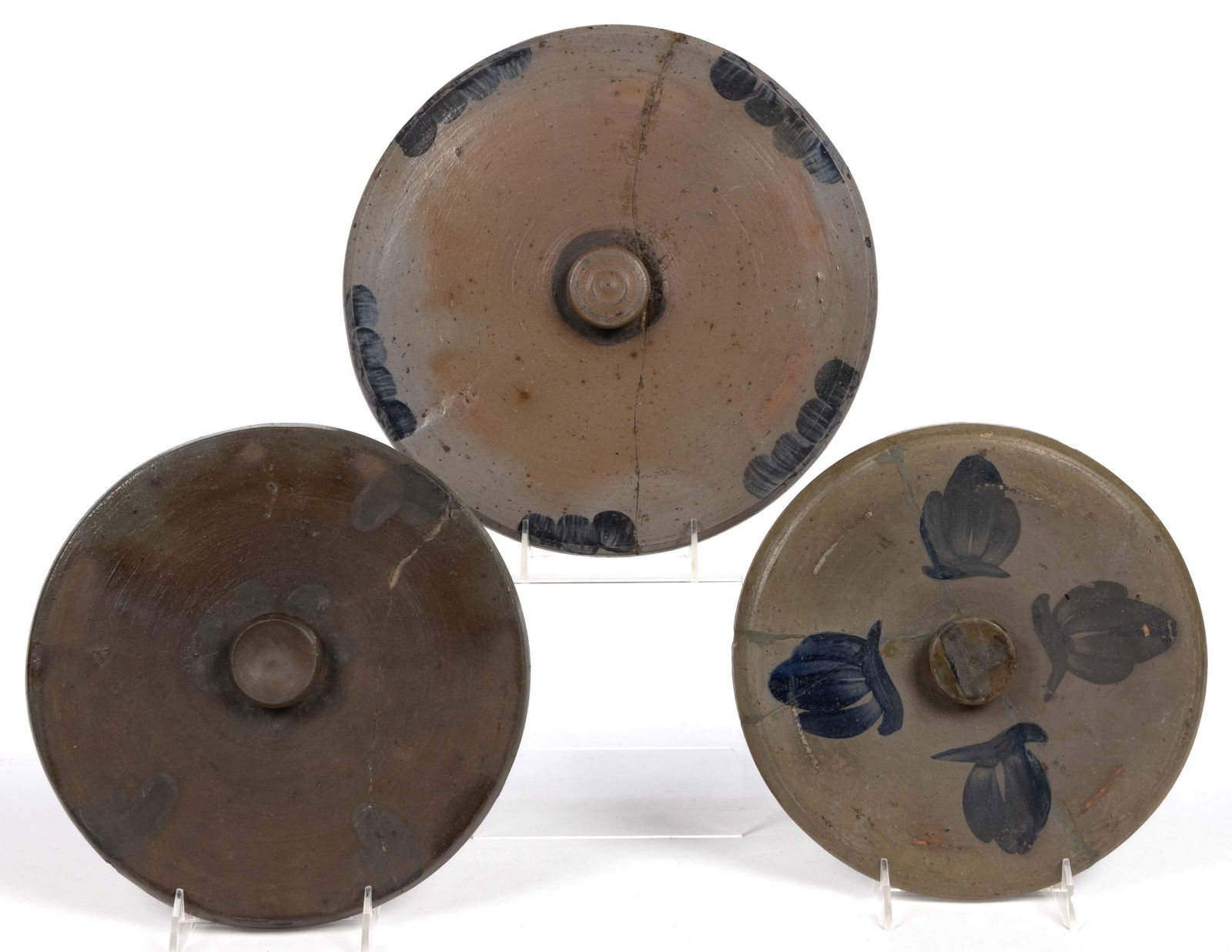 MID-ATLANTIC DECORATED STONEWARE COVERS, LOT OF THREE: MID-ATLANTIC DECORATED STONEWARE COVERS, LOT OF THREE, salt-glazed, each of circular form including one having four arches to interior flange. Each having brushed cobalt decorations including one havi