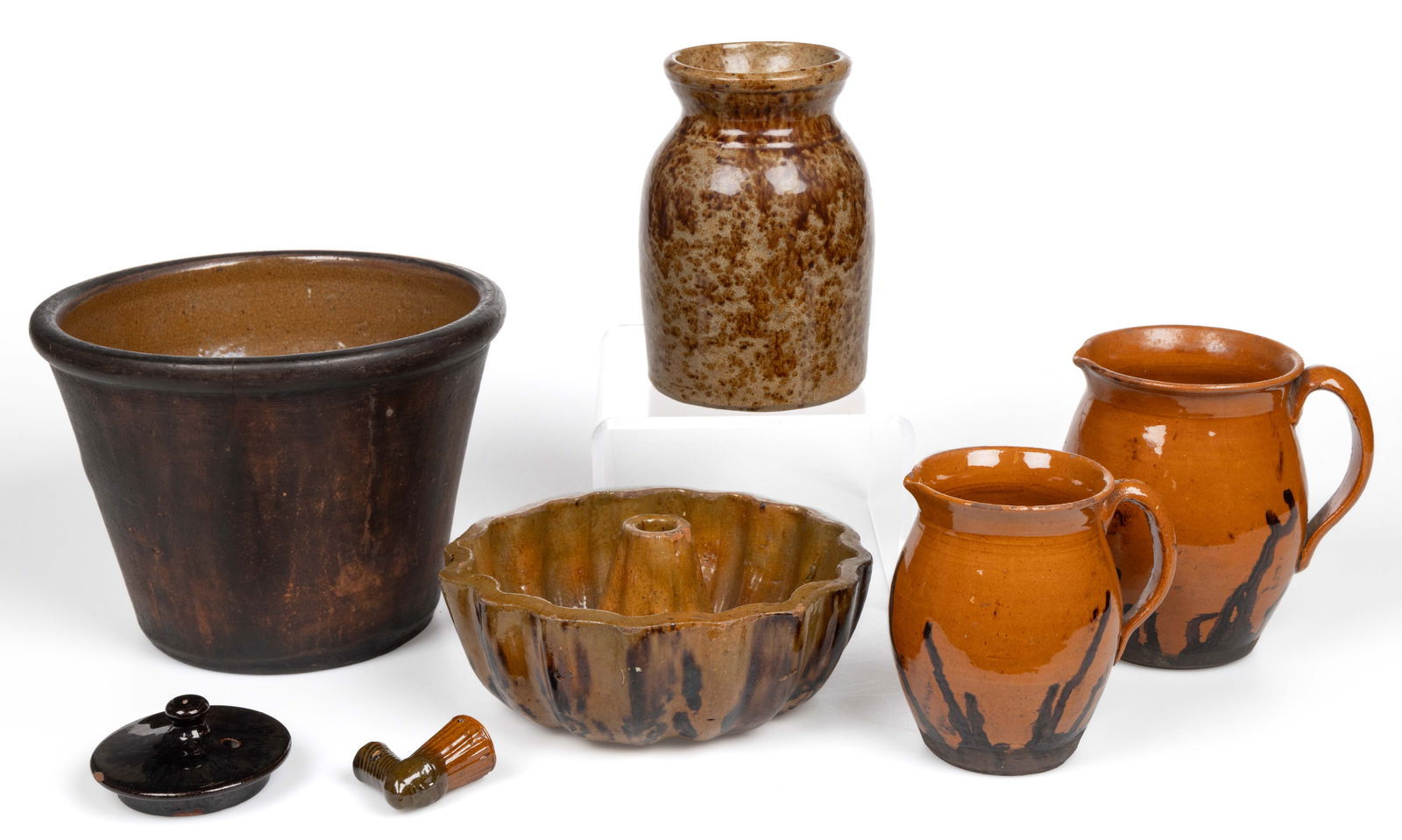AMERICAN AND OTHER EARTHENWARE / REDWARE ARTICLES, LOT OF SIX: AMERICAN AND OTHER EARTHENWARE / REDWARE ARTICLES, LOT OF SIX, lead-glazed, including a pipe bowl with molded face and ribbed stem, a single-glazed deep, conical-form pan with rounded rim, and fo