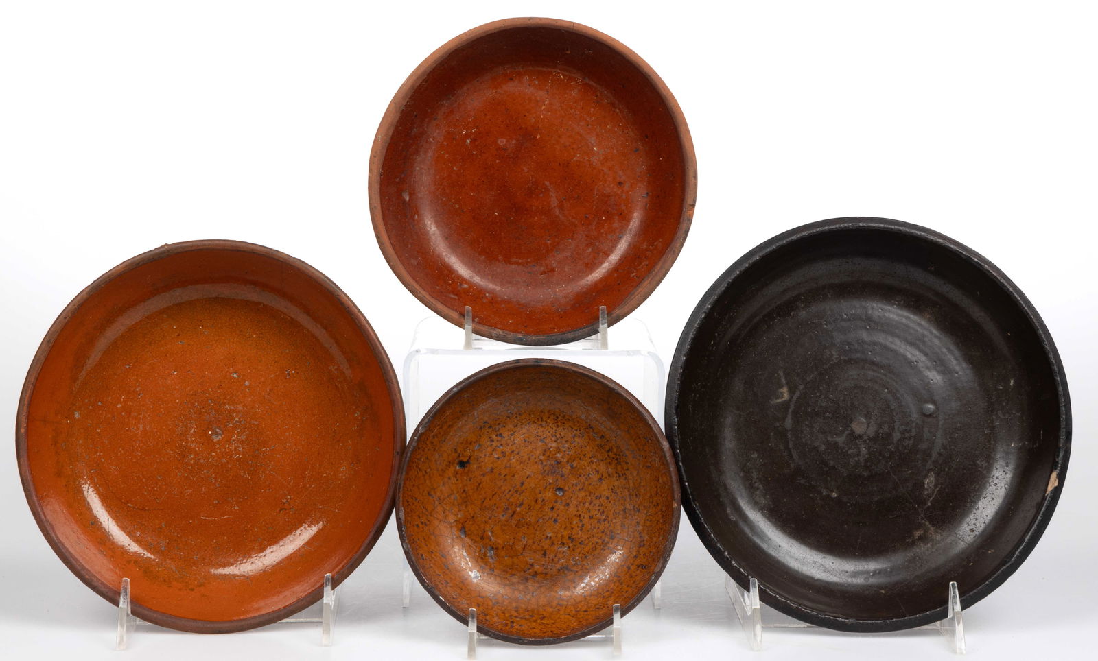 AMERICAN EARTHENWARE / REDWARE DISHES / PANS, LOT OF FOUR: AMERICAN EARTHENWARE / REDWARE DISHES / PANS, LOT OF FOUR, each single-glazed interior, comprising three lead-glazed examples and one brown-glazed example. 19th/early 20th century. 7 3/4" DOA. Pr