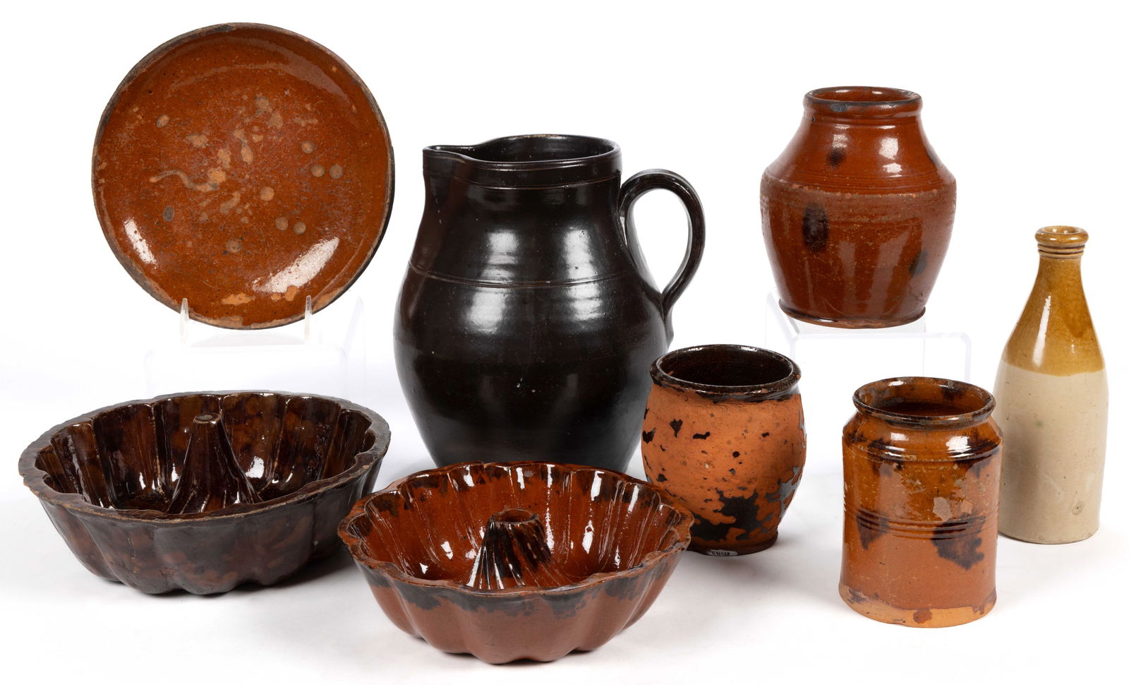 AMERICAN EARTHENWARE / REDWARE KITCHEN ARTICLES, LOT OF SEVEN: AMERICAN EARTHENWARE / REDWARE KITCHEN ARTICLES, LOT OF SEVEN, comprising one Albany-slip glaze pitcher and six lead-glazed examples including three jars and two cake molds. Together with a Briti
