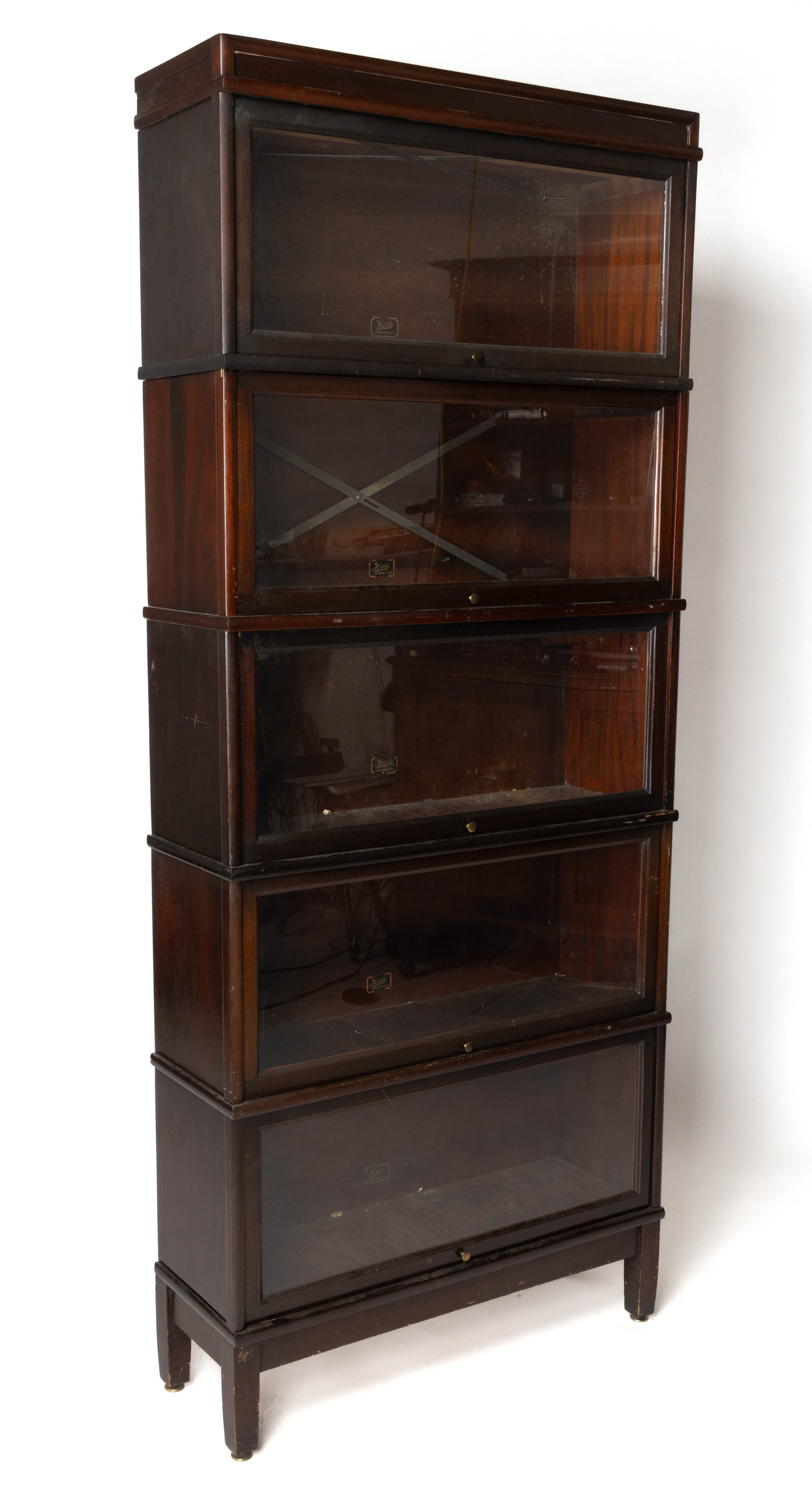 HALE MAHOGANY BARRISTER BOOKCASE: HALE MAHOGANY BARRISTER BOOKCASE, in five stacking sections each section with a fold-up and sliding glass door, all above a base section raised on four square tapered legs. Re