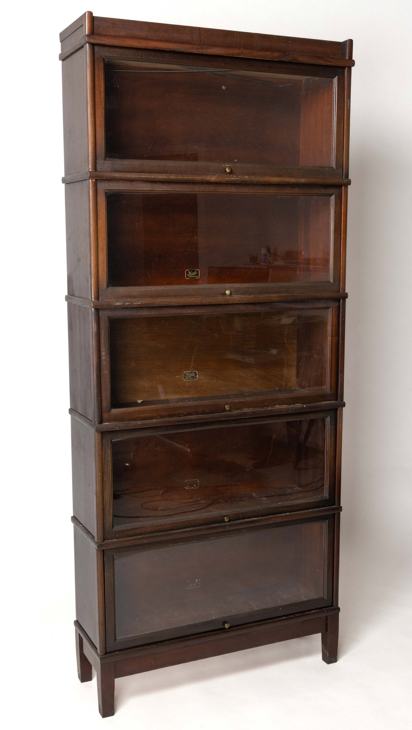 HALE MAHOGANY BARRISTER BOOKCASE: HALE MAHOGANY BARRISTER BOOKCASE, in five stacking sections each section with a fold-up and sliding glass door, all above a base section raised on four square tapered legs. Re