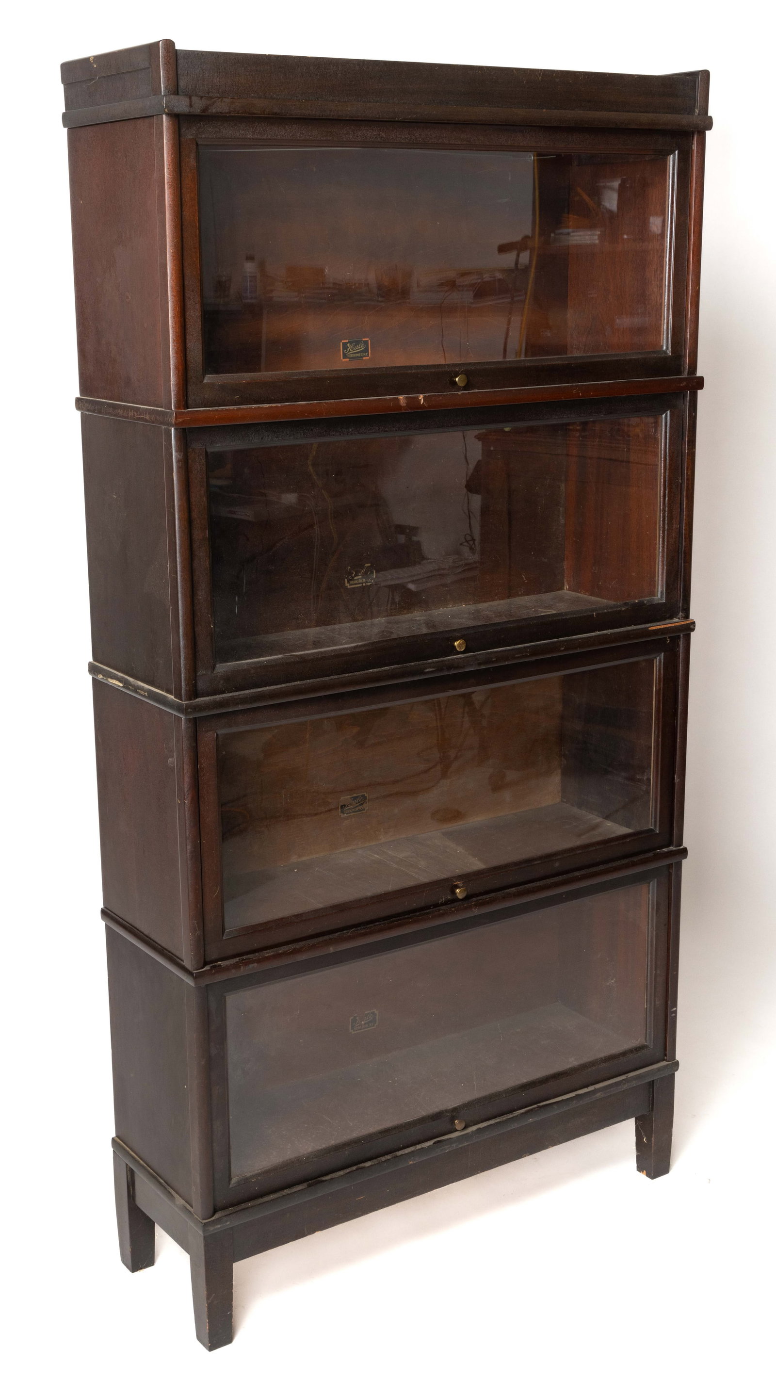 HALE MAHOGANY BARRISTER BOOKCASE: HALE MAHOGANY BARRISTER BOOKCASE, in four stacking sections each section with a fold-up and sliding glass door, all above a base section raised on four square tapered legs. Re