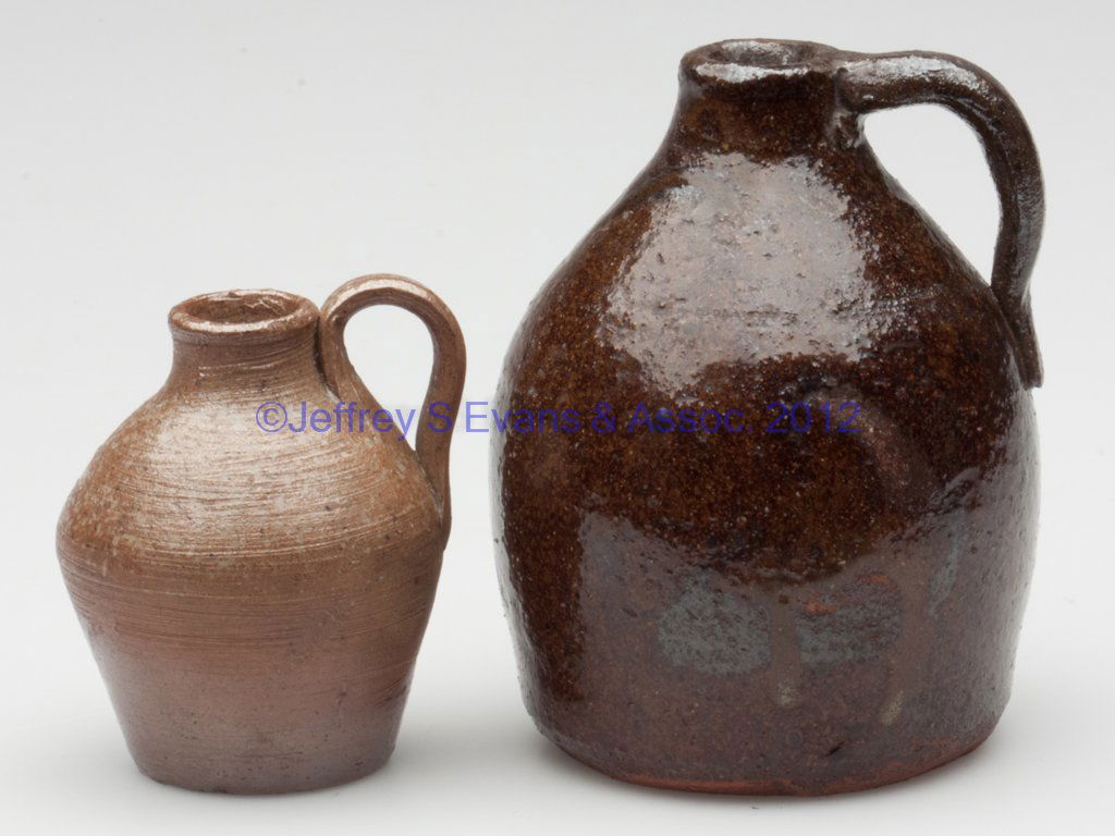 SOUTHERN POTTERY MINIATURE / TOY JUGS, LOT OF TWO: SOUTHERN POTTERY MINIATURE / TOY JUGS, LOT OF TWO, comprising a small salt-glazed stoneware example, very finely potted with a delicate strap handle, and a manganese and lead-glazed earthenware exampl
