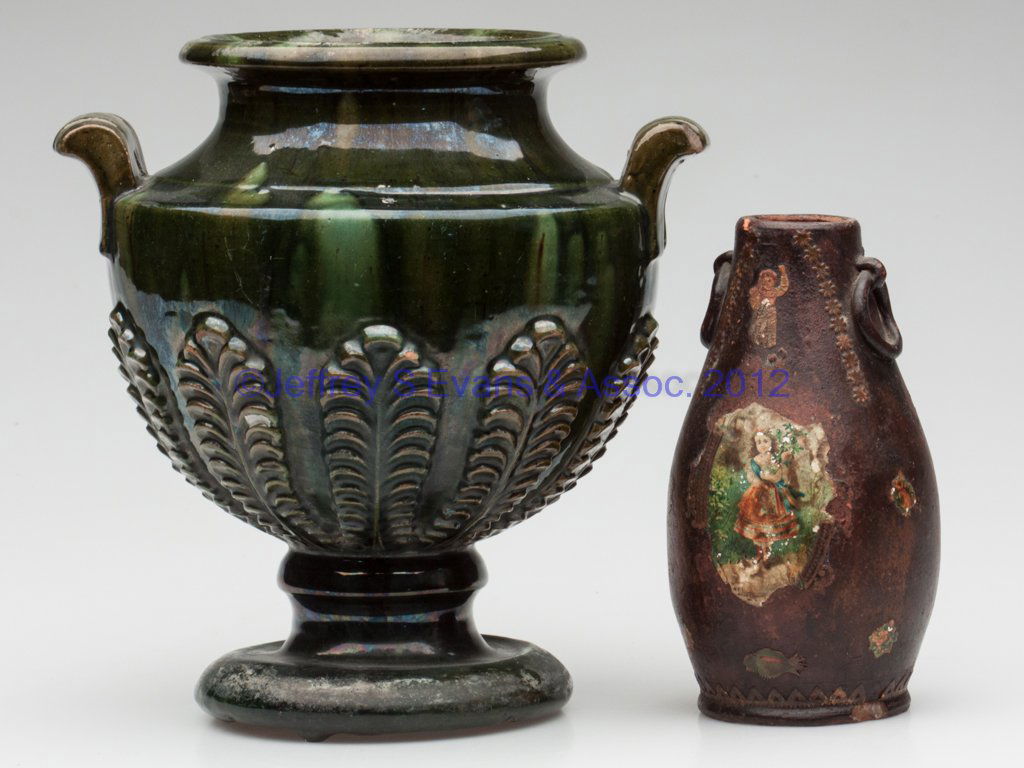 DECORATED EARTHENWARE VASE AND URN: DECORATED EARTHENWARE VASE AND URN, comprising an unglazed vase with molded ring handles and applied/varnished diecuts, and a lead and copper-glazed urn with molded upright ferns around lower body, pu