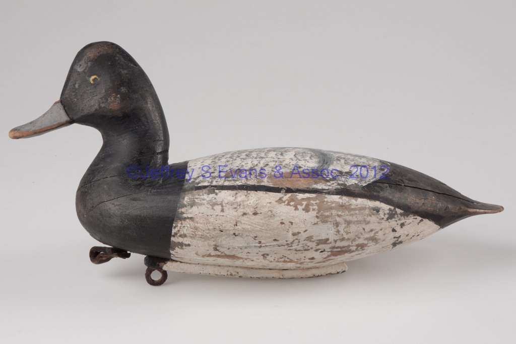 SCAUP DRAKE DECOY: SCAUP DRAKE DECOY, carved and painted wood, applied head, old overpaint, underbase stamped "J.B.R" and with narrow weight. 20th century. 6 3/4" H, 13 1/2" L. Provenance: The collection of Sally and th