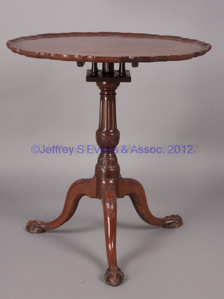 CENTENNIAL CHIPPENDALE MAHOGANY TEA TABLE: CENTENNIAL CHIPPENDALE MAHOGANY TEA TABLE, scallop-edge molded dish top and bird-cage support, raised on a carved pedestal and tripod base with elongated claw feet. Fourth quarter 19th century. 29 1/4