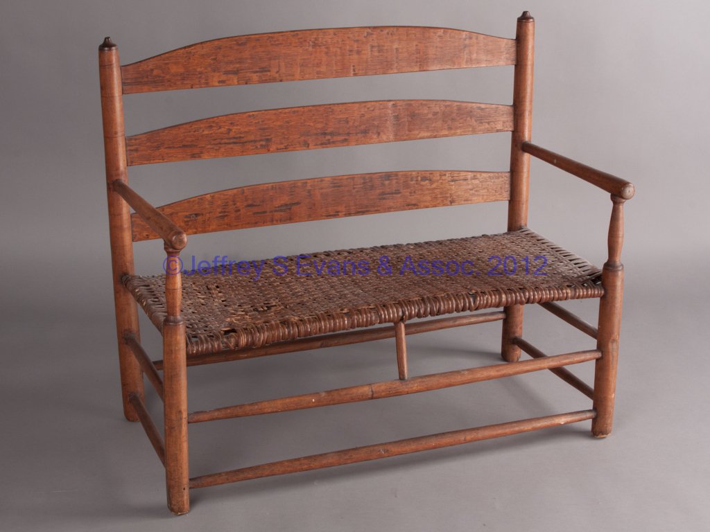 AMERICAN COUNTRY SETTEE / WAGON SEAT: AMERICAN COUNTRY SETTEE / WAGON SEAT, three-slat back, tapered round arms, and woven splint seat, raised on legs joined by double stretchers. Mid 19th century. 30 1/2" HOA, 13" H seat, 35" L. Provenan