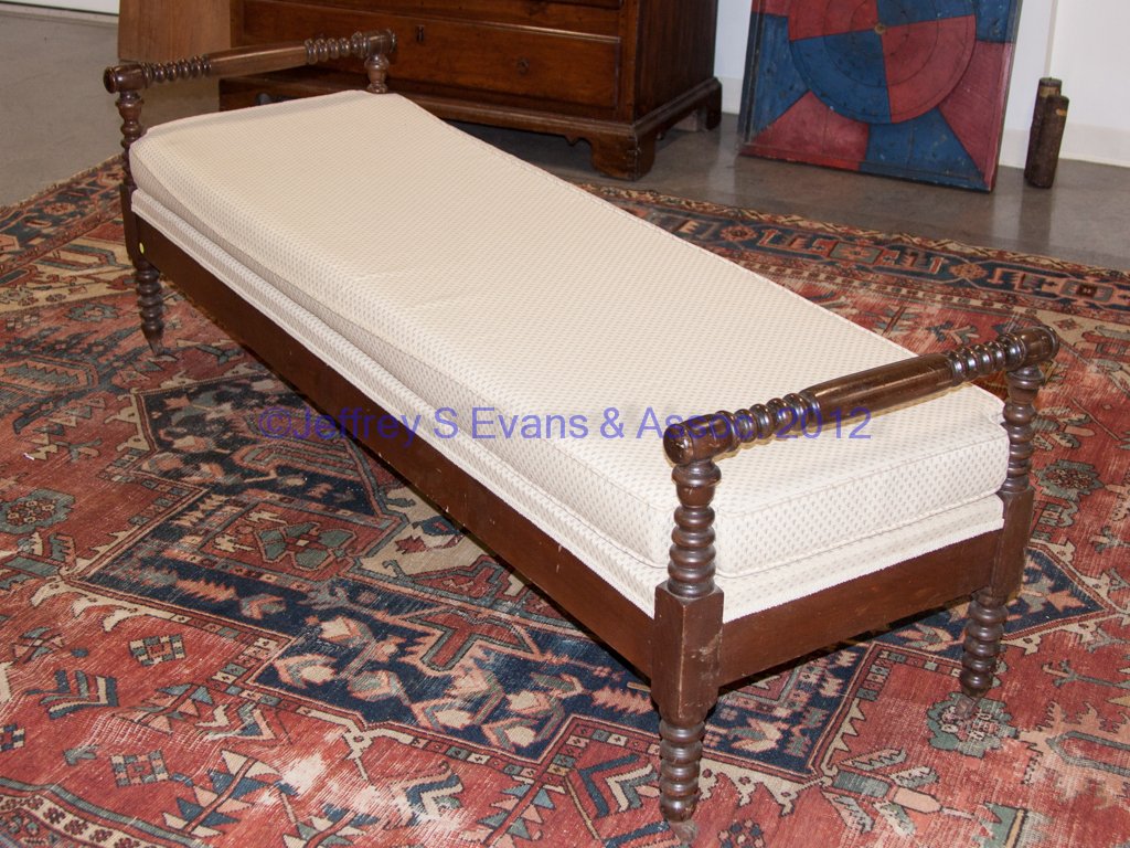 AMERICAN WALNUT DAY BED: AMERICAN WALNUT DAY BED, spool-type turned posts and crest rails, custom-made cushion. Mid 19th century. 23" H, 23" x 72". Provenance: The collection of Sally and the late Stanley Greenbaum, Williamsb