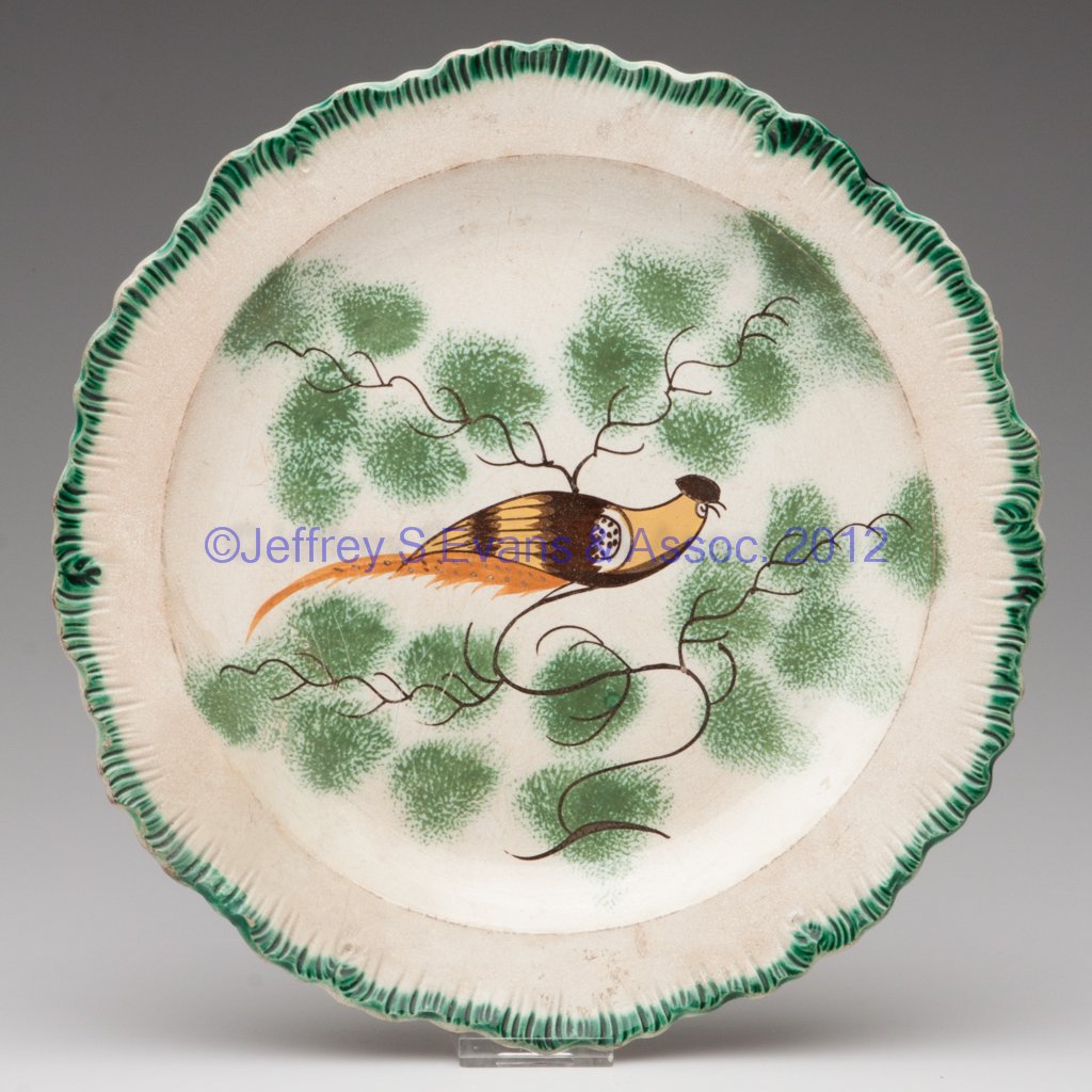 ENGLISH EMBOSSED-EDGE PEARLWARE DINNER PLATE PAINT: ENGLISH EMBOSSED-EDGE PEARLWARE DINNER PLATE PAINTED WITH PEAFOWL, scallop-rimmed form with green-painted border, centering a brown, ochre, orange and medium brown peafowl facing to the right on exten