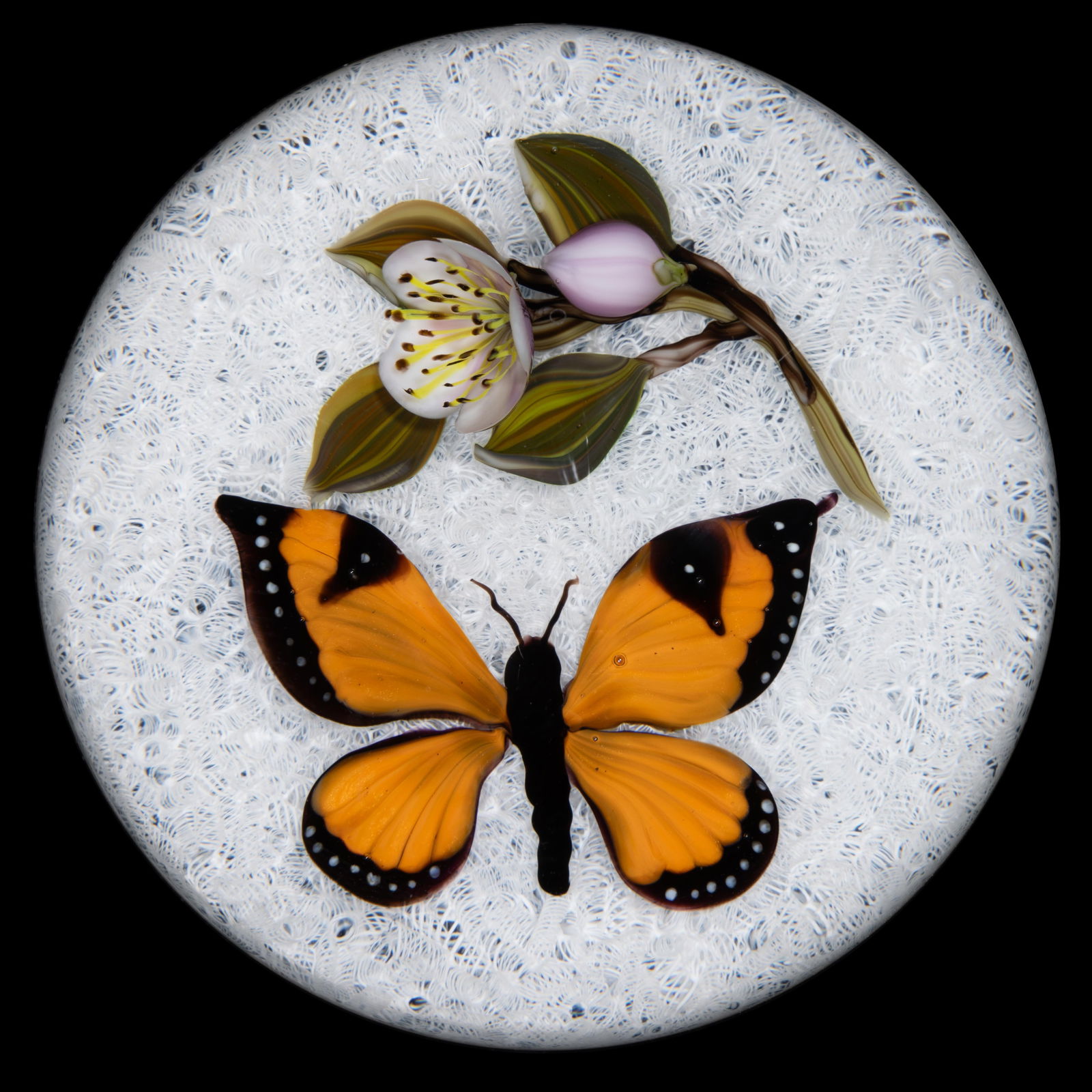 VICTOR TRABUCCO (AMERICAN, B. 1949) BUTTERFLY AND FLOWER LAMPWORK STUDIO ART GLASS PAPERWEIGHT: VICTOR TRABUCCO (AMERICAN, B. 1949) BUTTERFLY AND FLOWER LAMPWORK STUDIO ART GLASS PAPERWEIGHT, large orange and black Monarch butterfly facing a single lavender and white blossom with a lower matchin