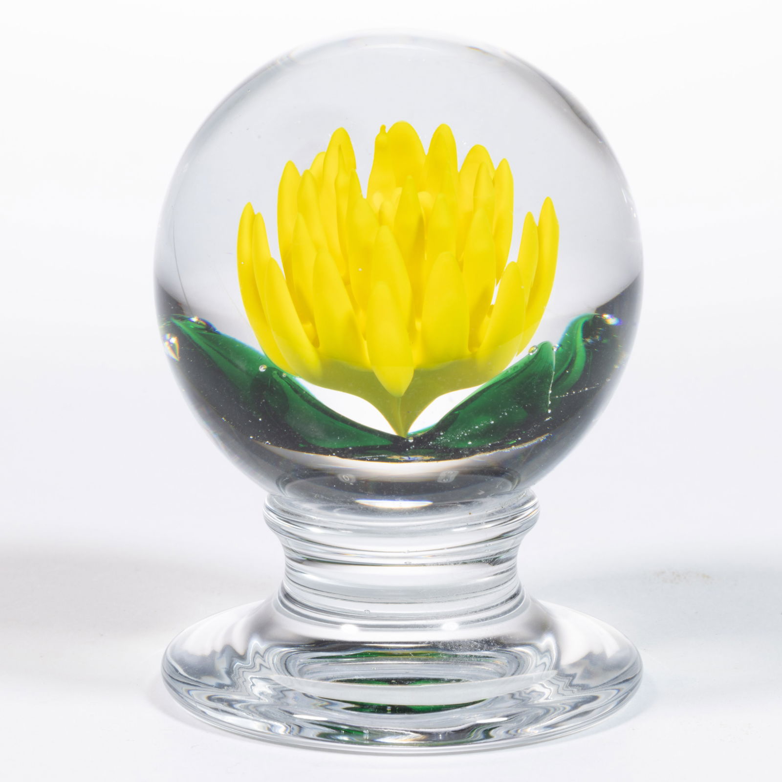 CHARLES KAZIUN JR. (AMERICAN, 1919-1992) CRIMP CROCUS LAMPWORK STUDIO ART GLASS PEDESTAL PAPERWEIGHT: CHARLES KAZIUN JR. (AMERICAN, 1919-1992) CRIMP CROCUS LAMPWORK STUDIO ART GLASS PEDESTAL PAPERWEIGHT, central yellow crimp flower with four protruding green leaves, signature cane to the underside, ra